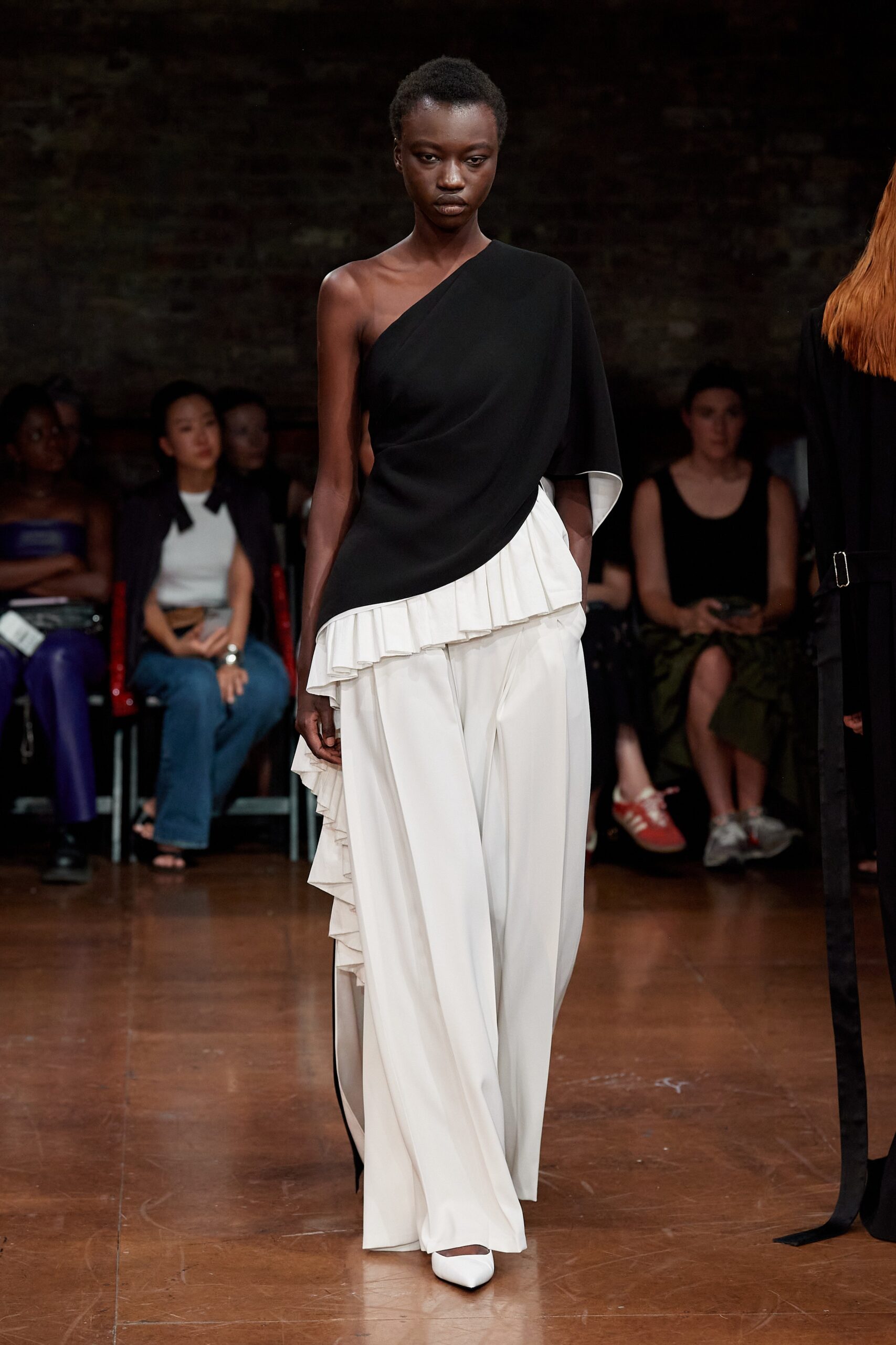 black asymmetric top with white pants