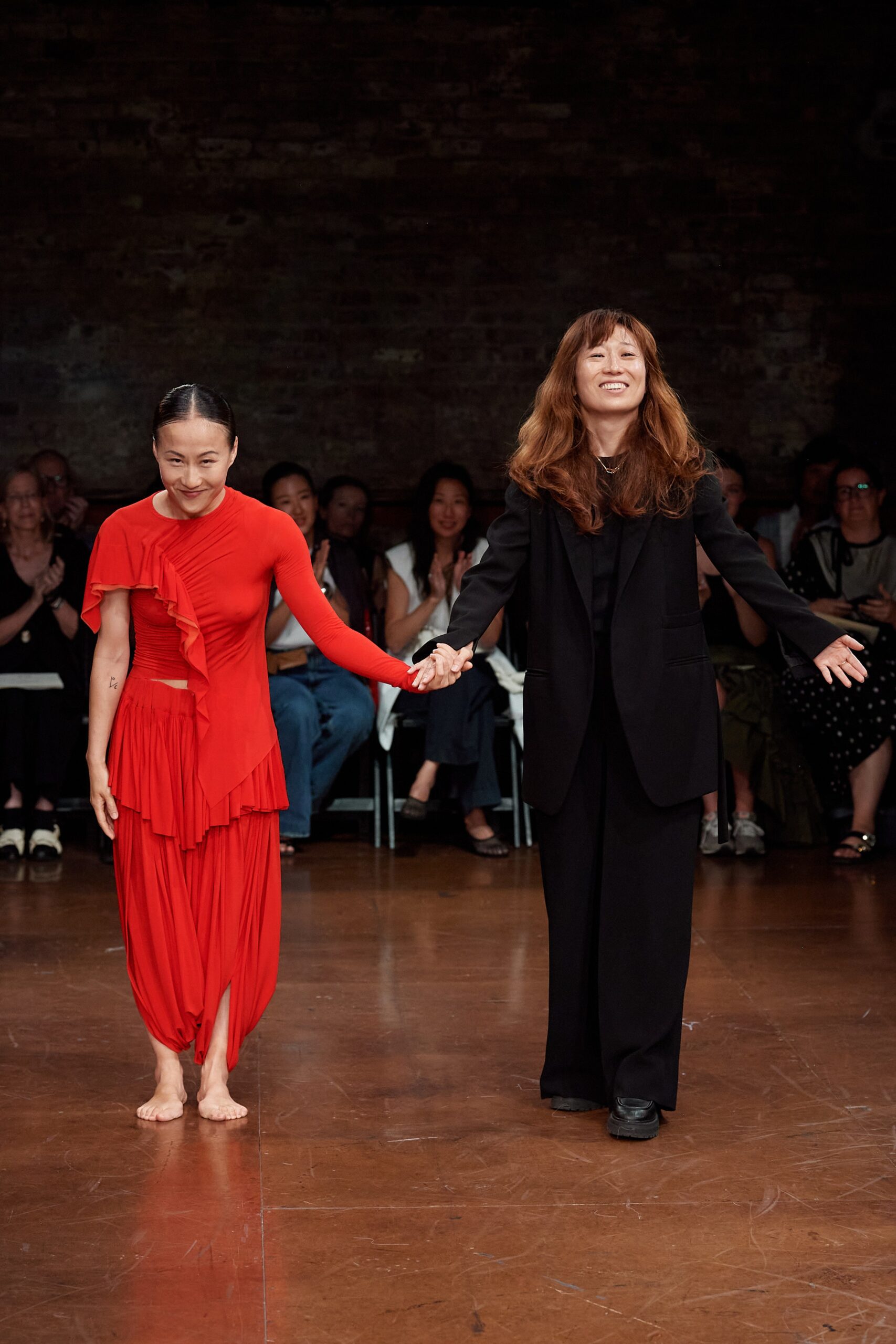 red pleated midi dress and black tailored suit