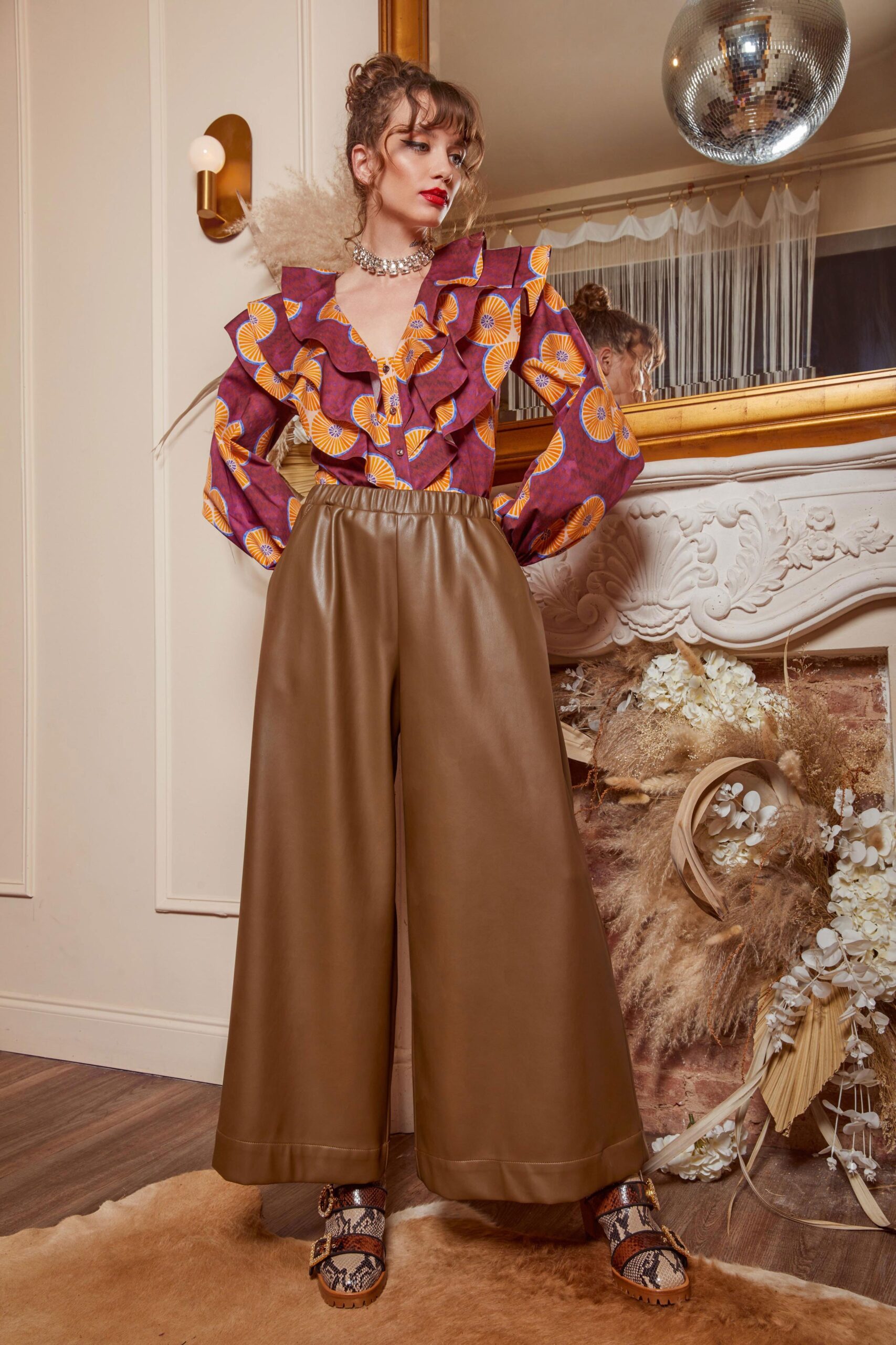 purple printed ruffled blouse with brown pants