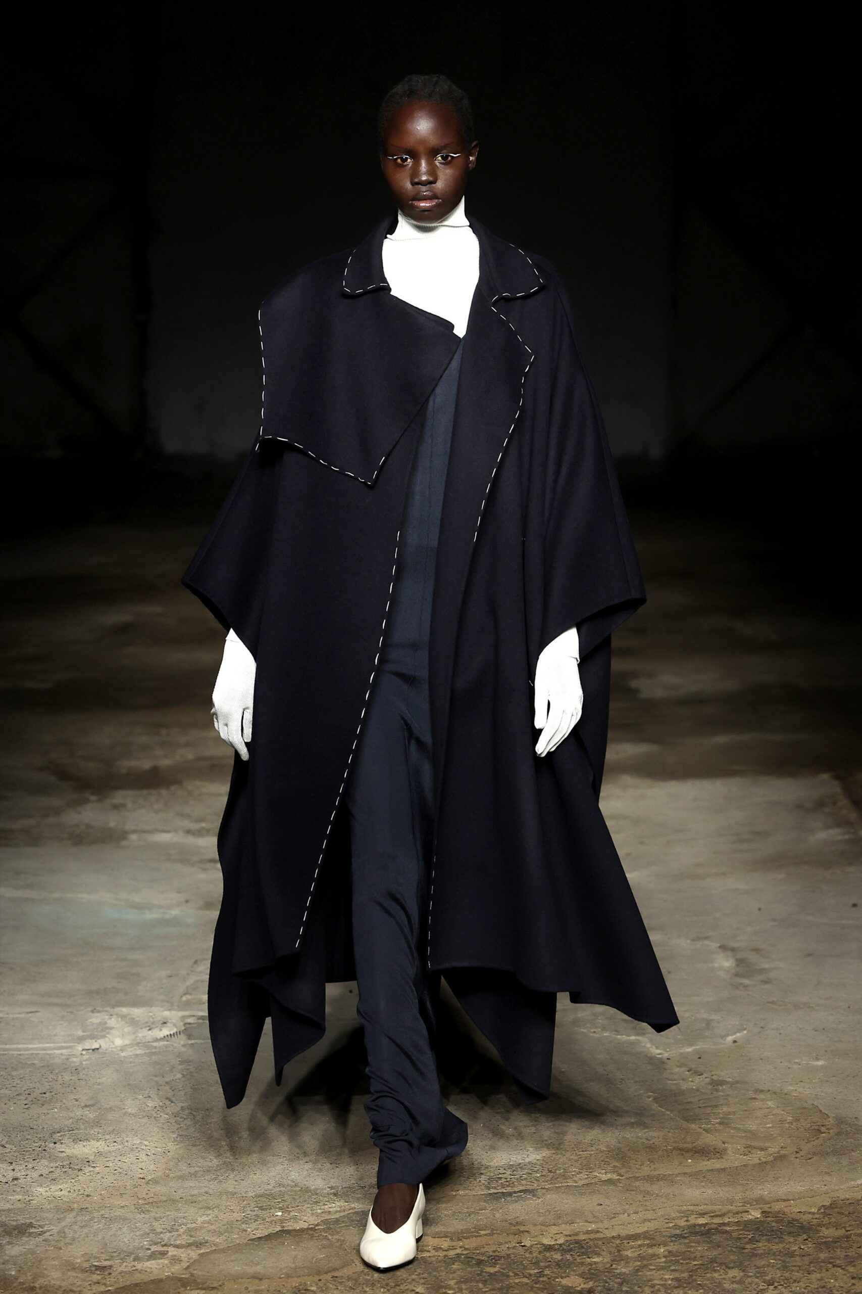 black wool cape and navy jumpsuit