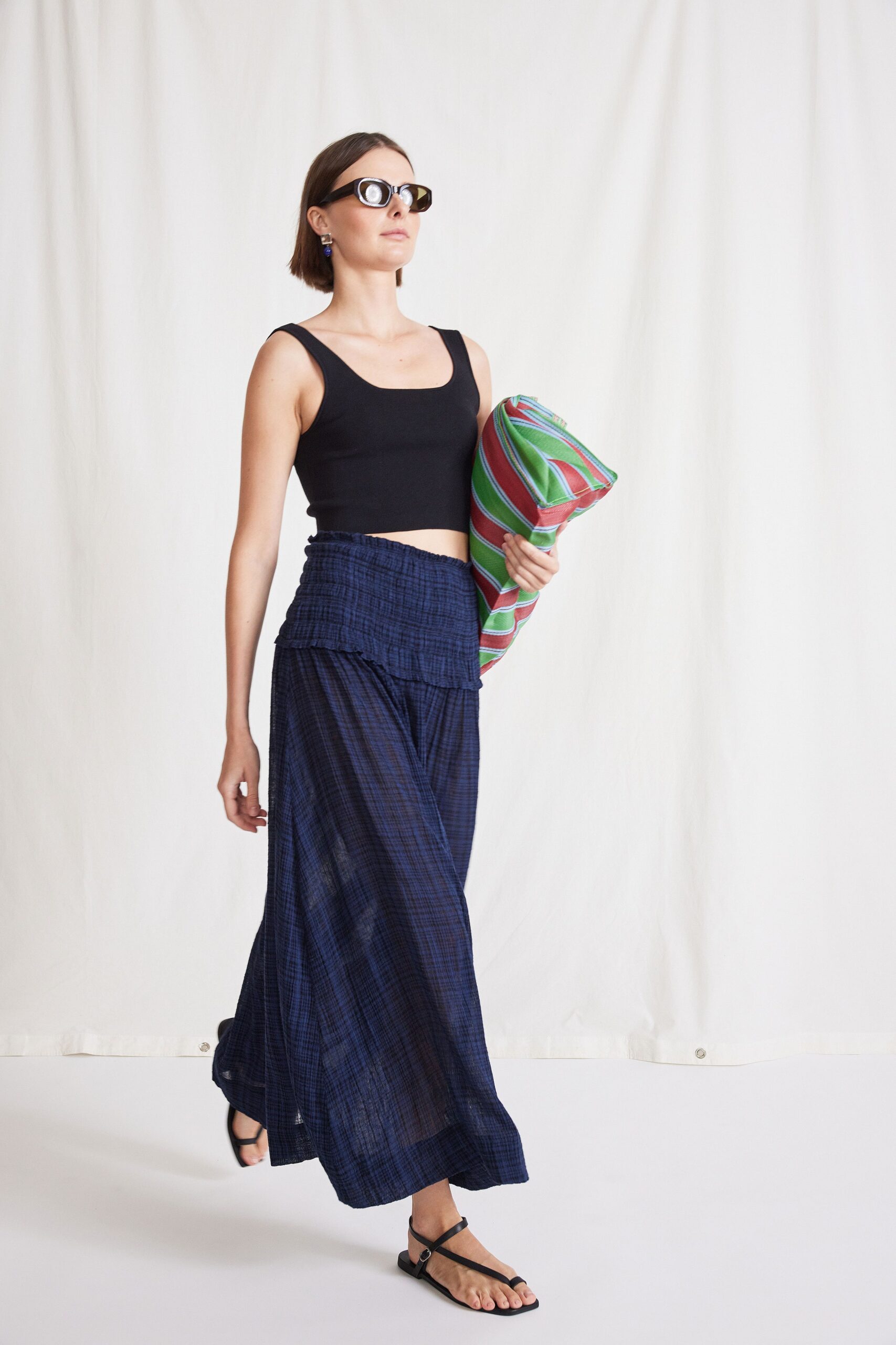 black fitted top and blue pleated skirt
