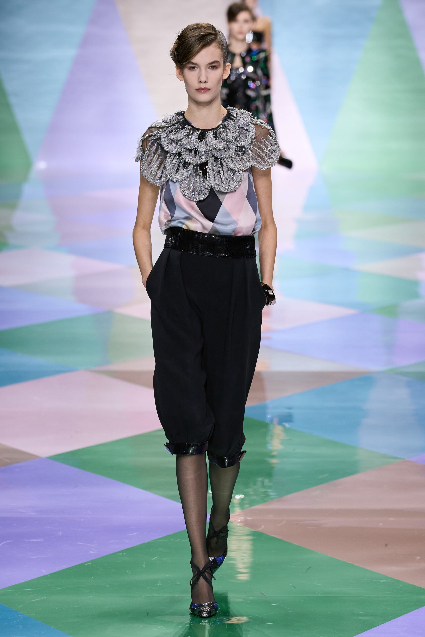 pink ruffled top with black pants