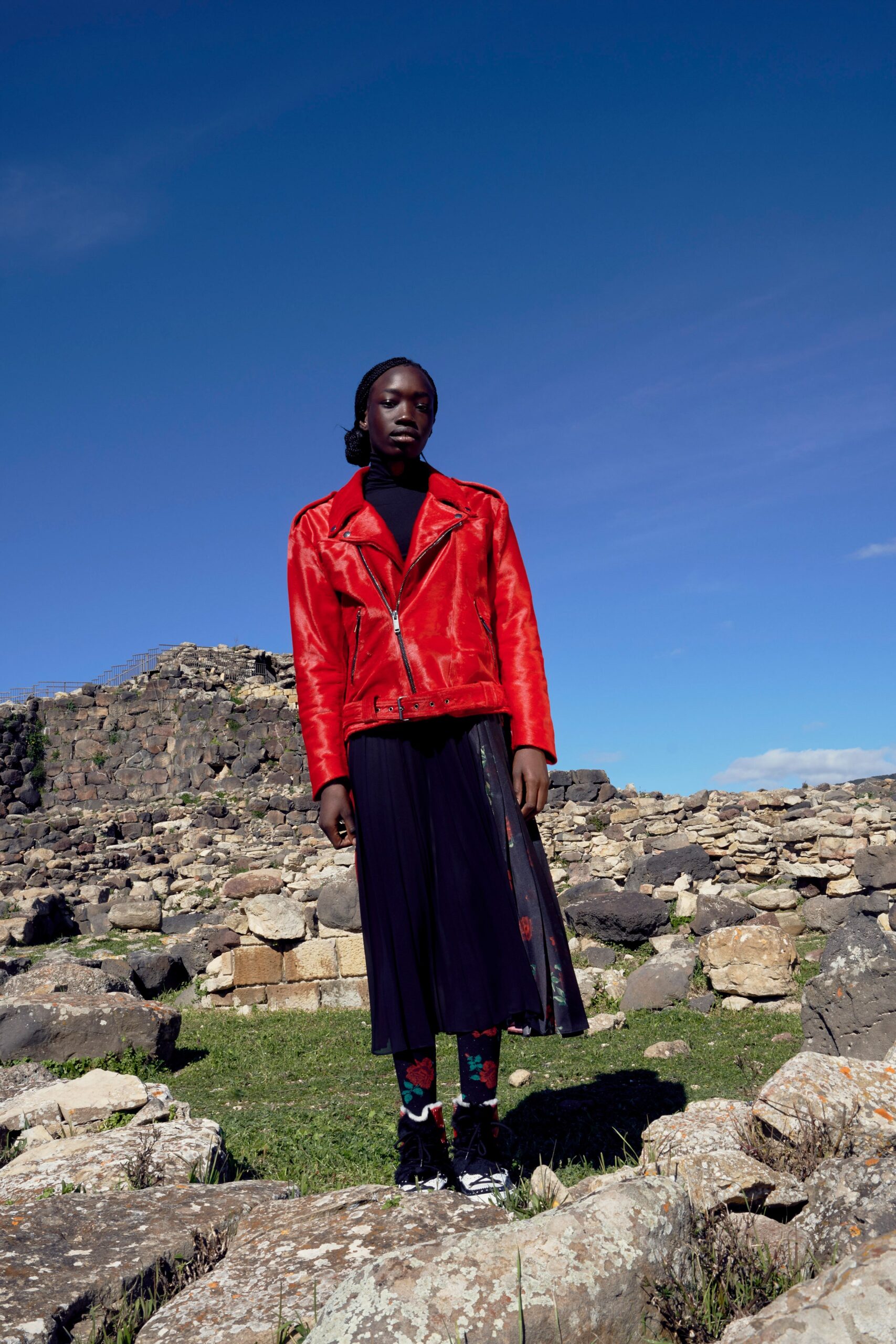 red leather fitted jacket and black pleated skirt
