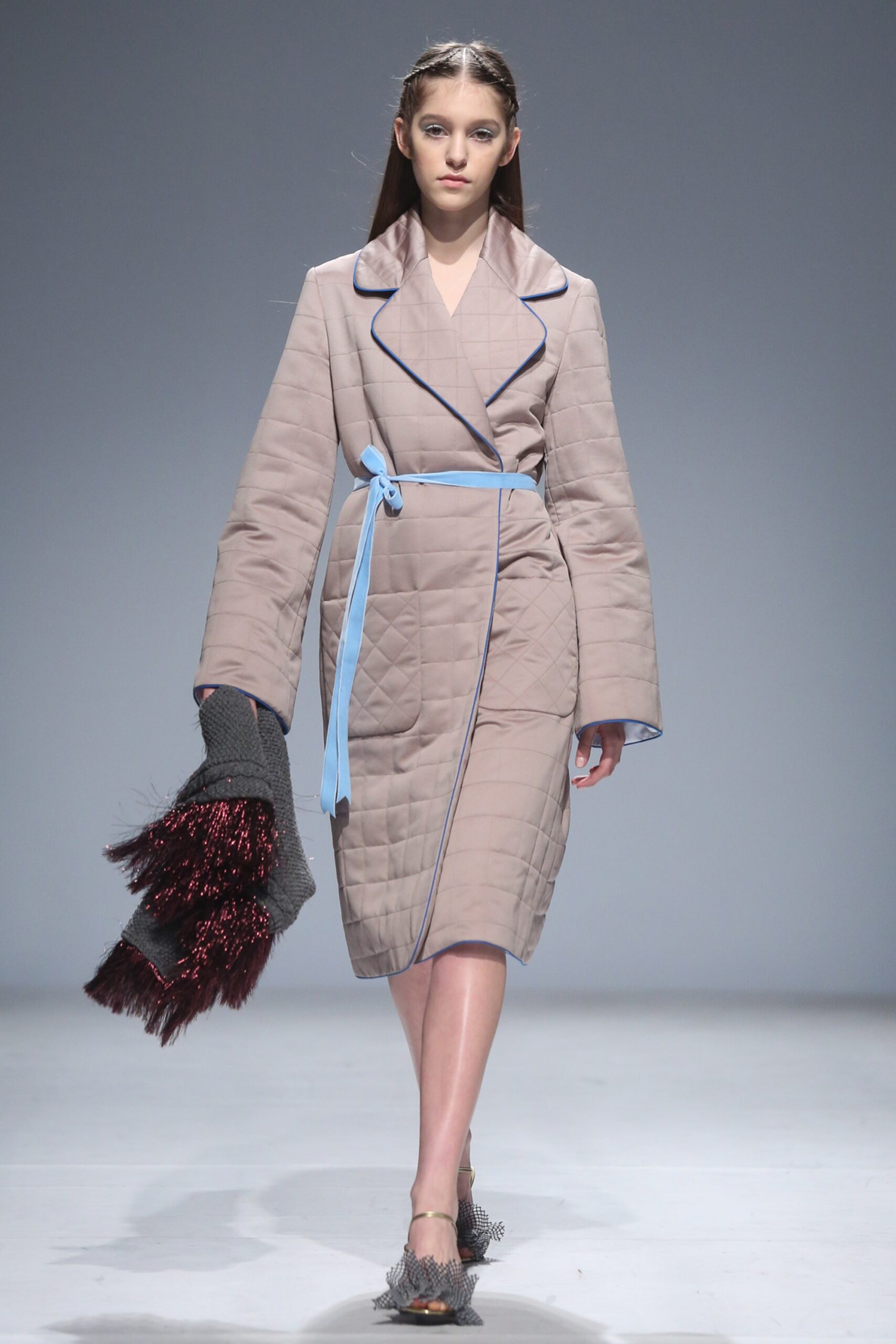 beige quilted coat with fringed bag