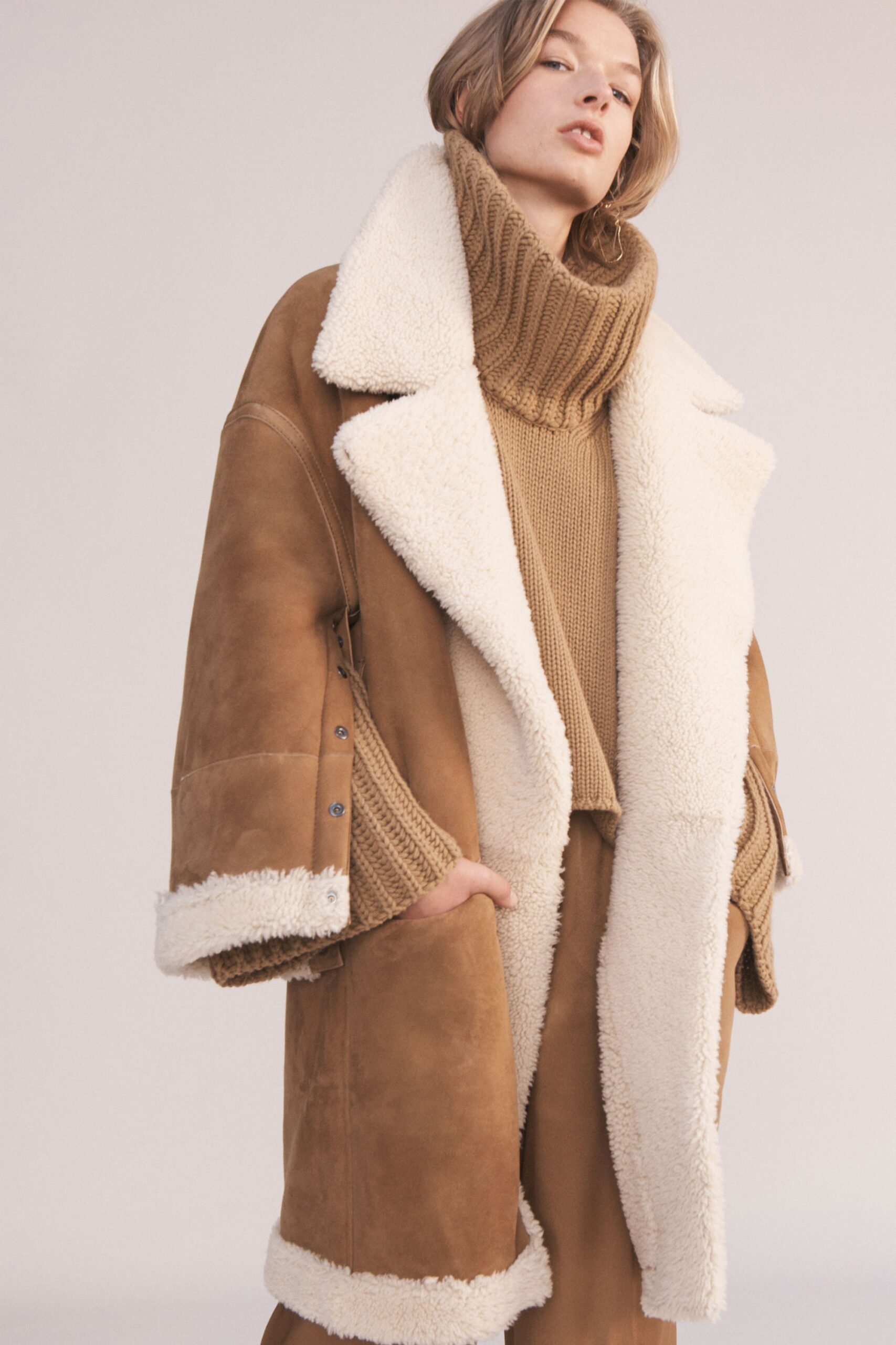 brown leather coat and beige sweater