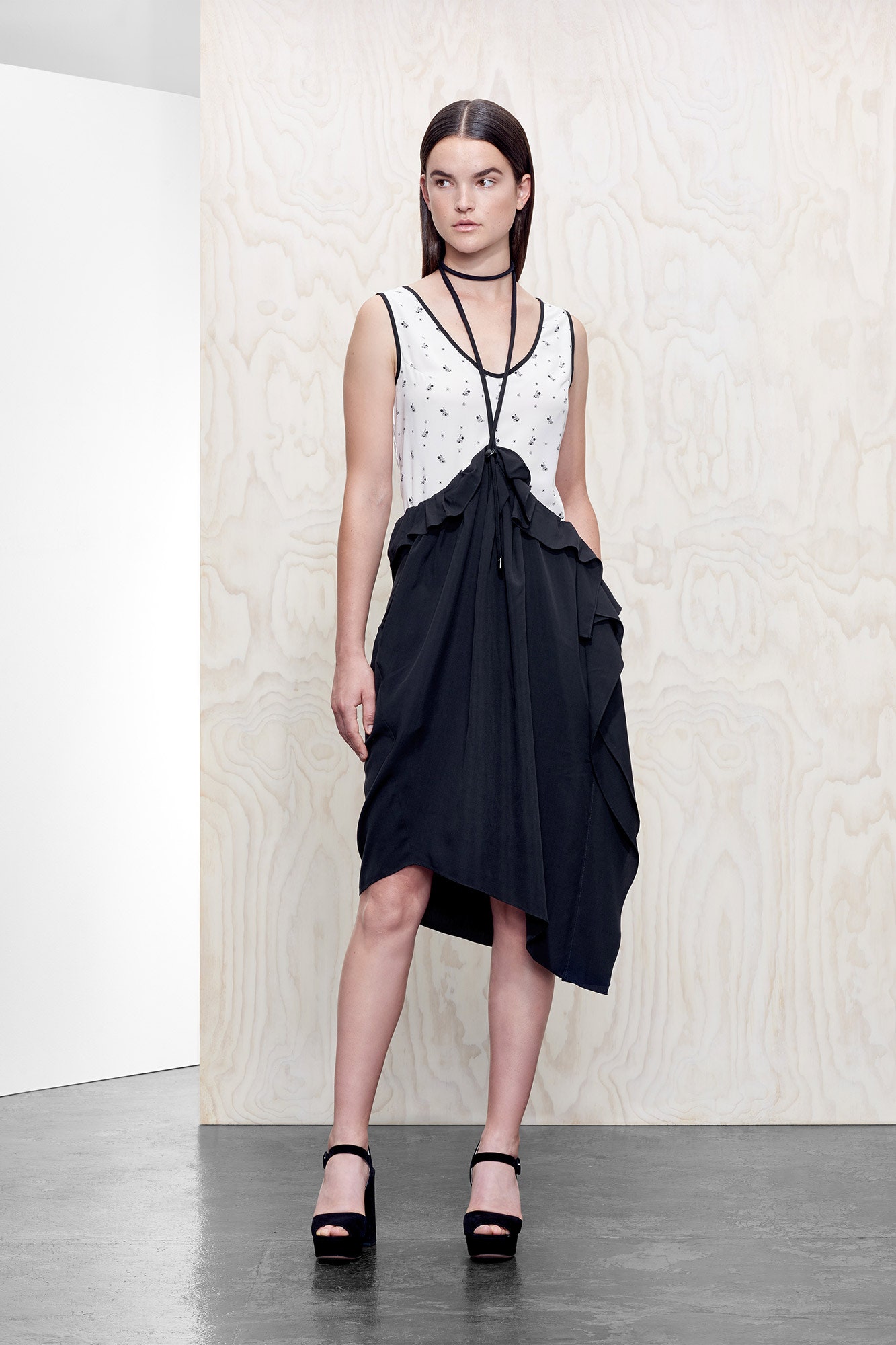 white embroidered sleeveless top and black asymmetric skirt