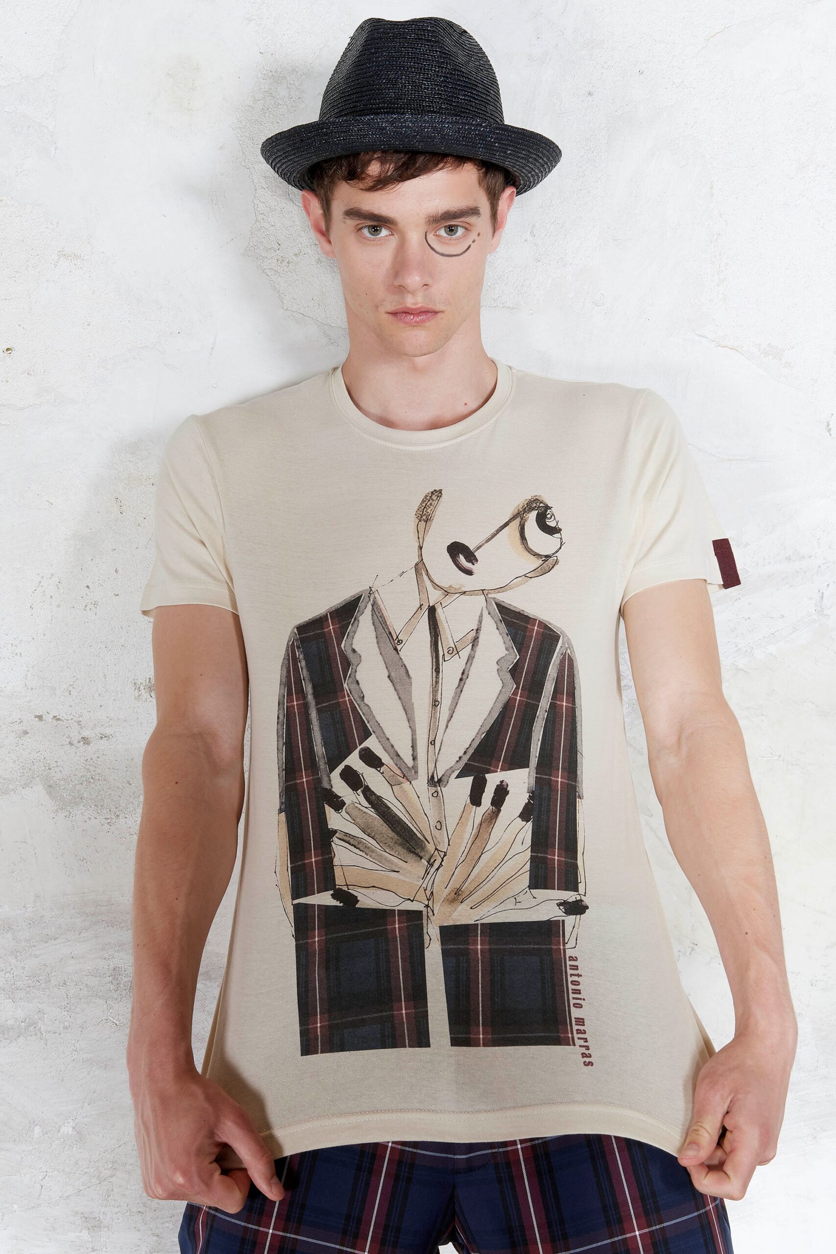 beige printed t-shirt with black hat
