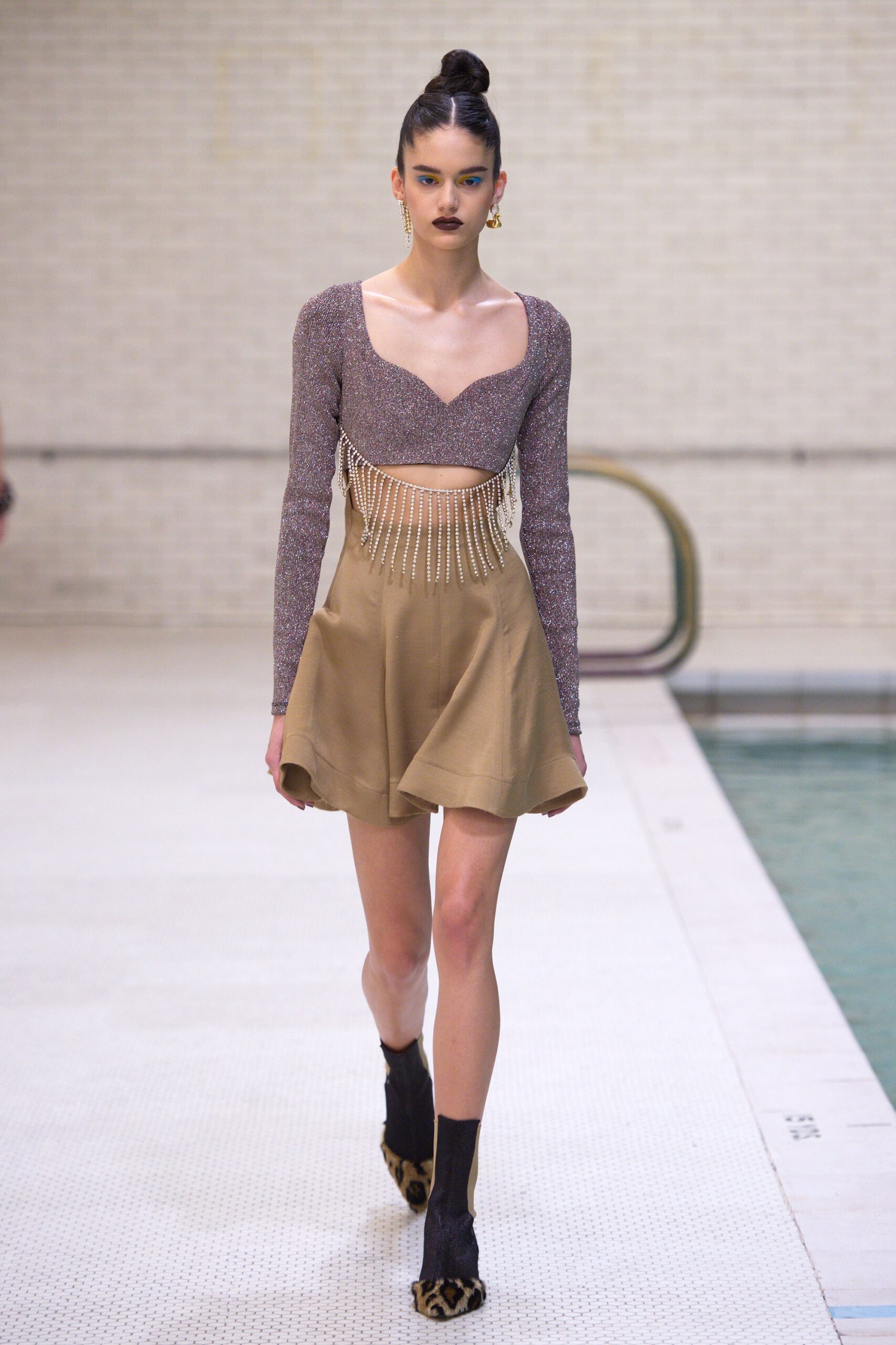 purple beaded top and beige flared skirt