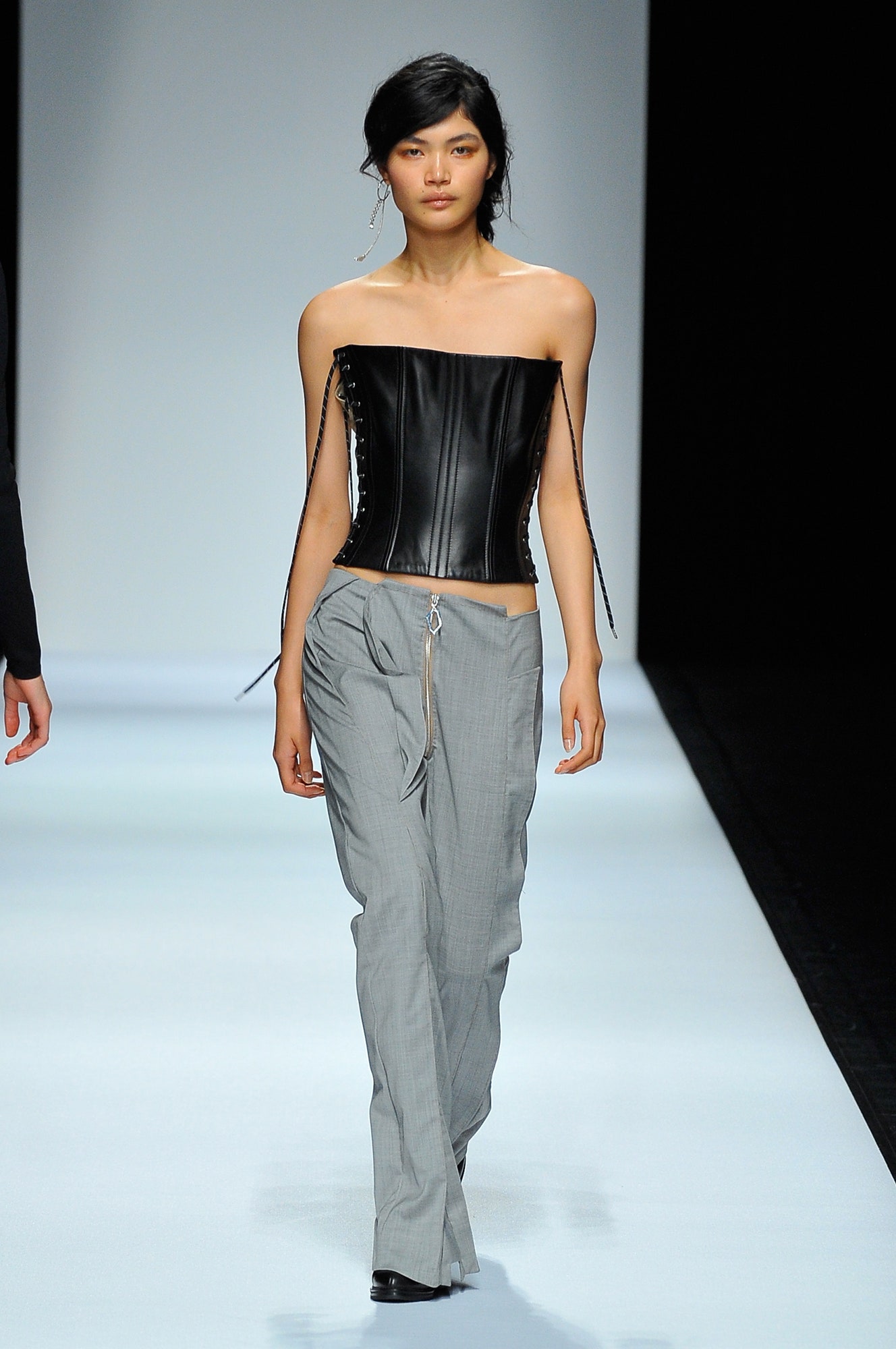 black leather corset and gray pants