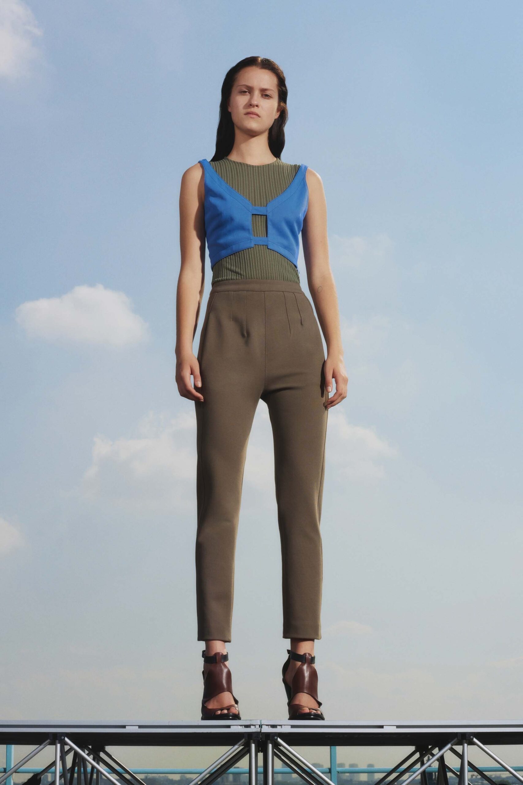 fitted blue and green top with slim brown pants