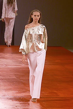 gold off-shoulder top and white tailored pants