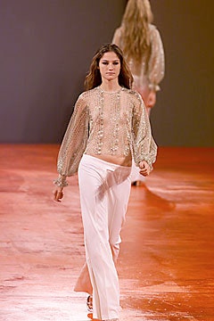 gold embellished top with white pants