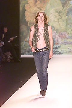 fitted green vest and blue jeans