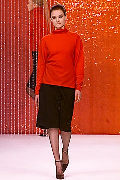 red fitted turtleneck top and black skirt