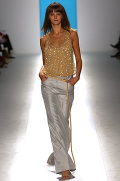 gold beaded sleeveless top with white pants