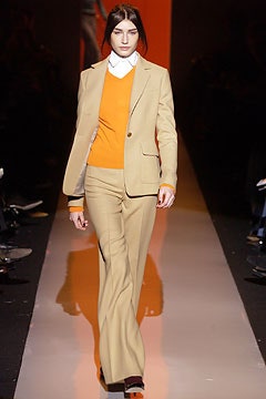 beige tailored suit with orange sweater