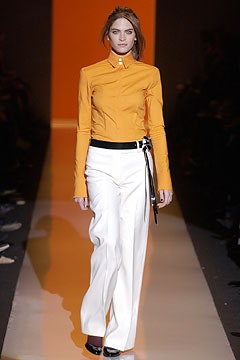 orange fitted shirt and white tailored pants