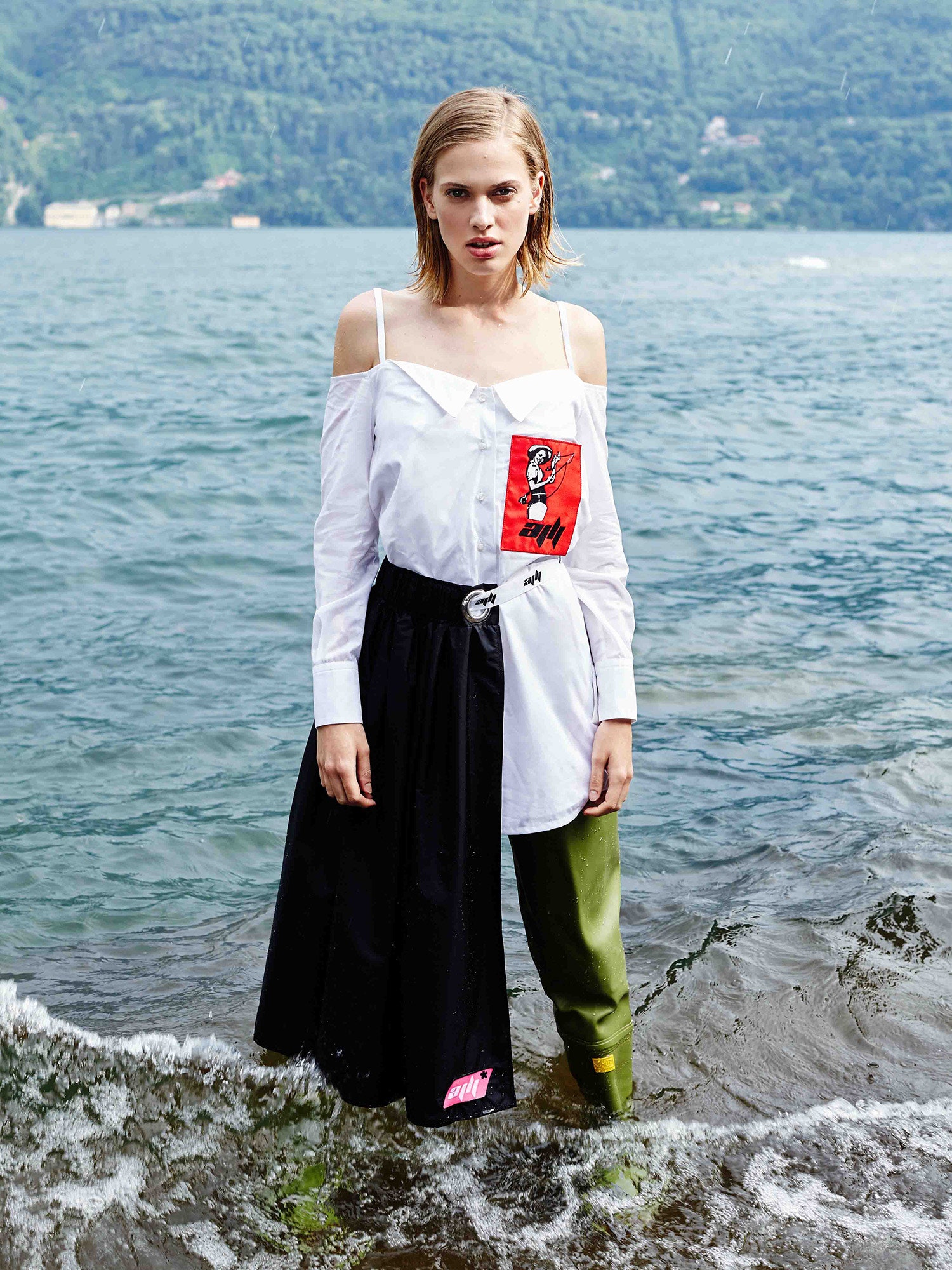 white off-shoulder shirt black pleated skirt green pants