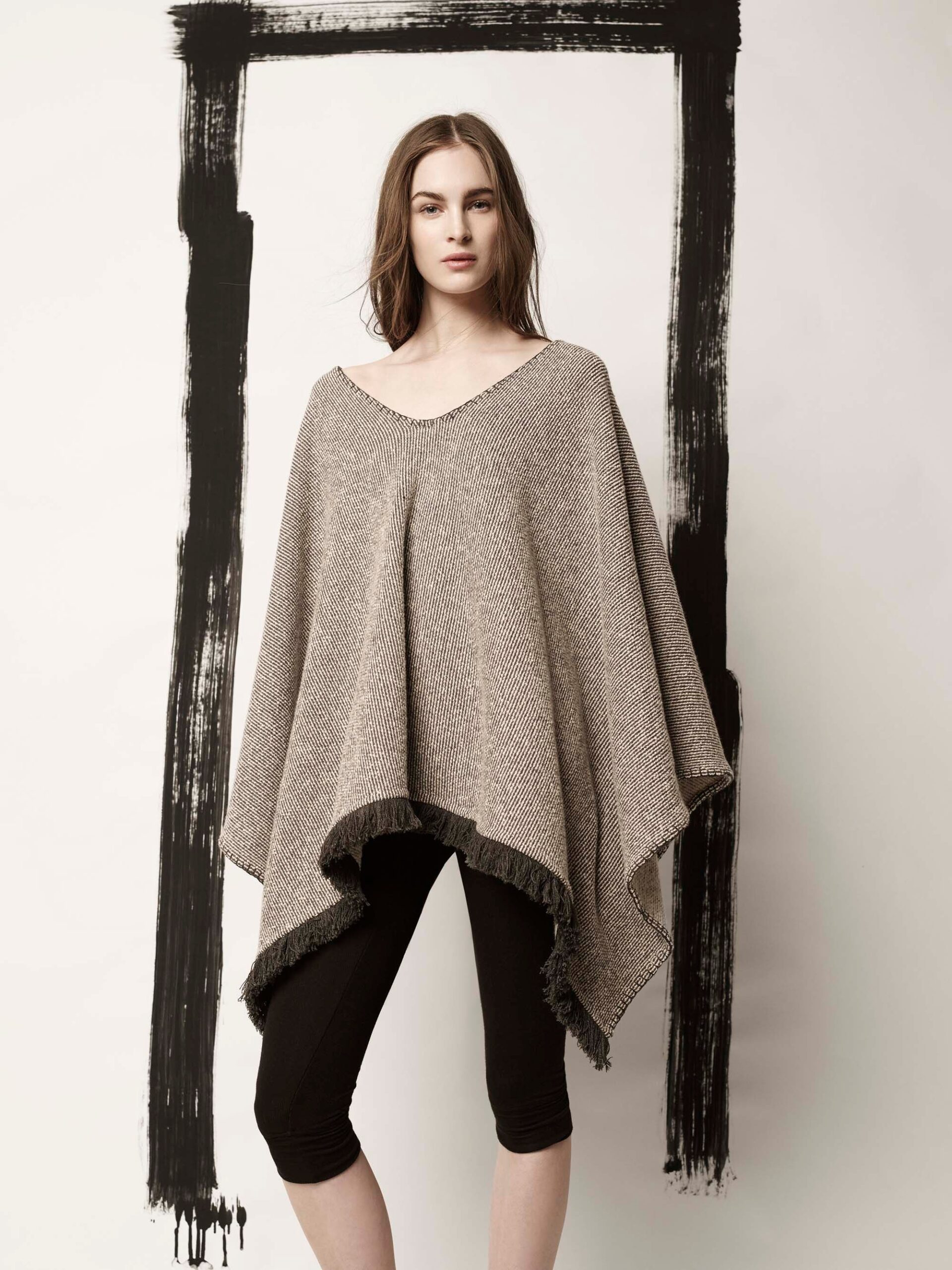 beige wool poncho with black leggings