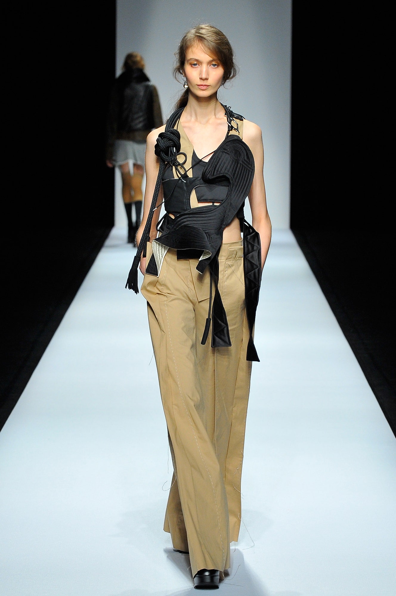 black leather sleeveless top and beige wide-leg pants