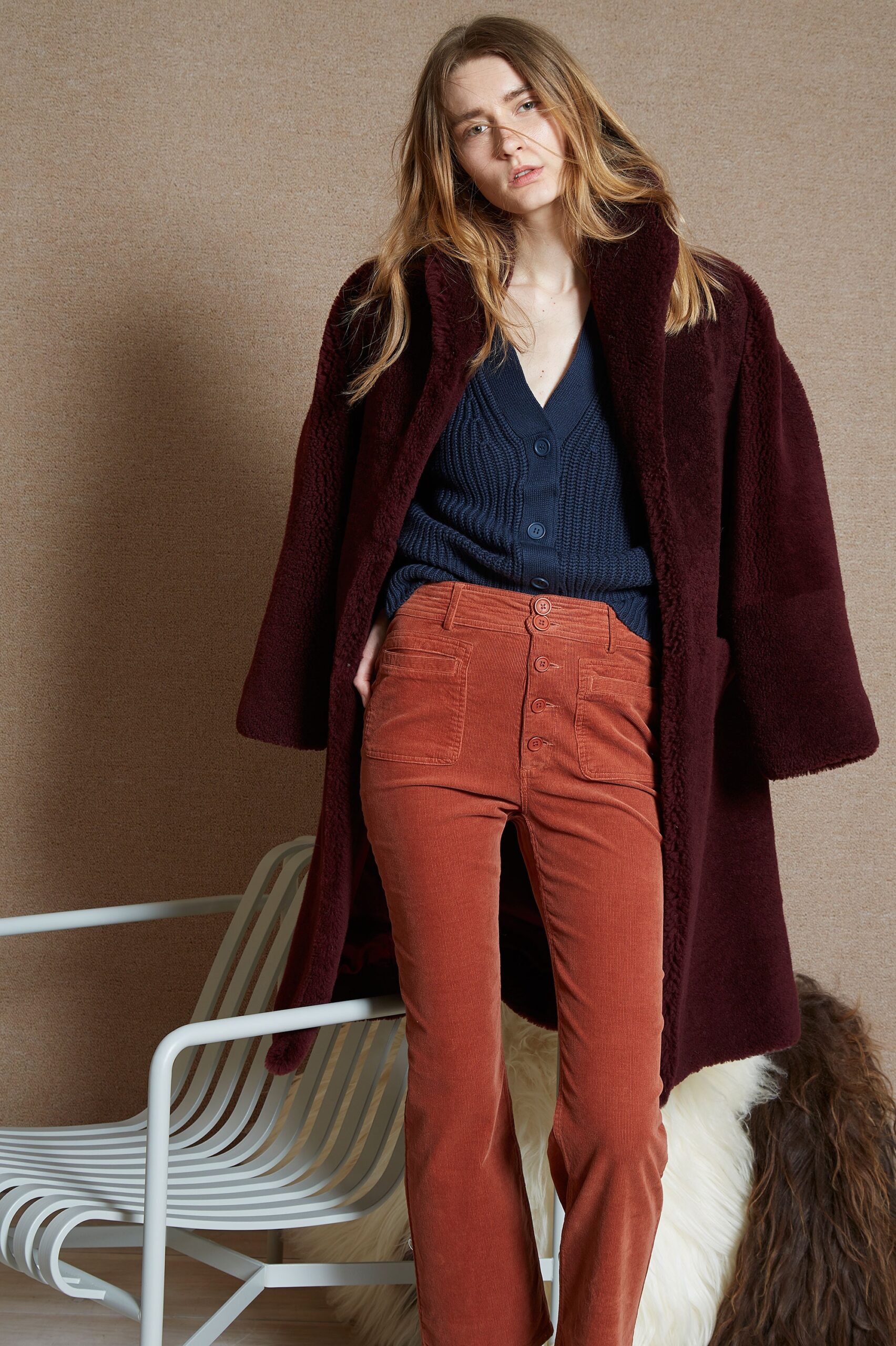 maroon faux-fur coat with navy top and orange pants