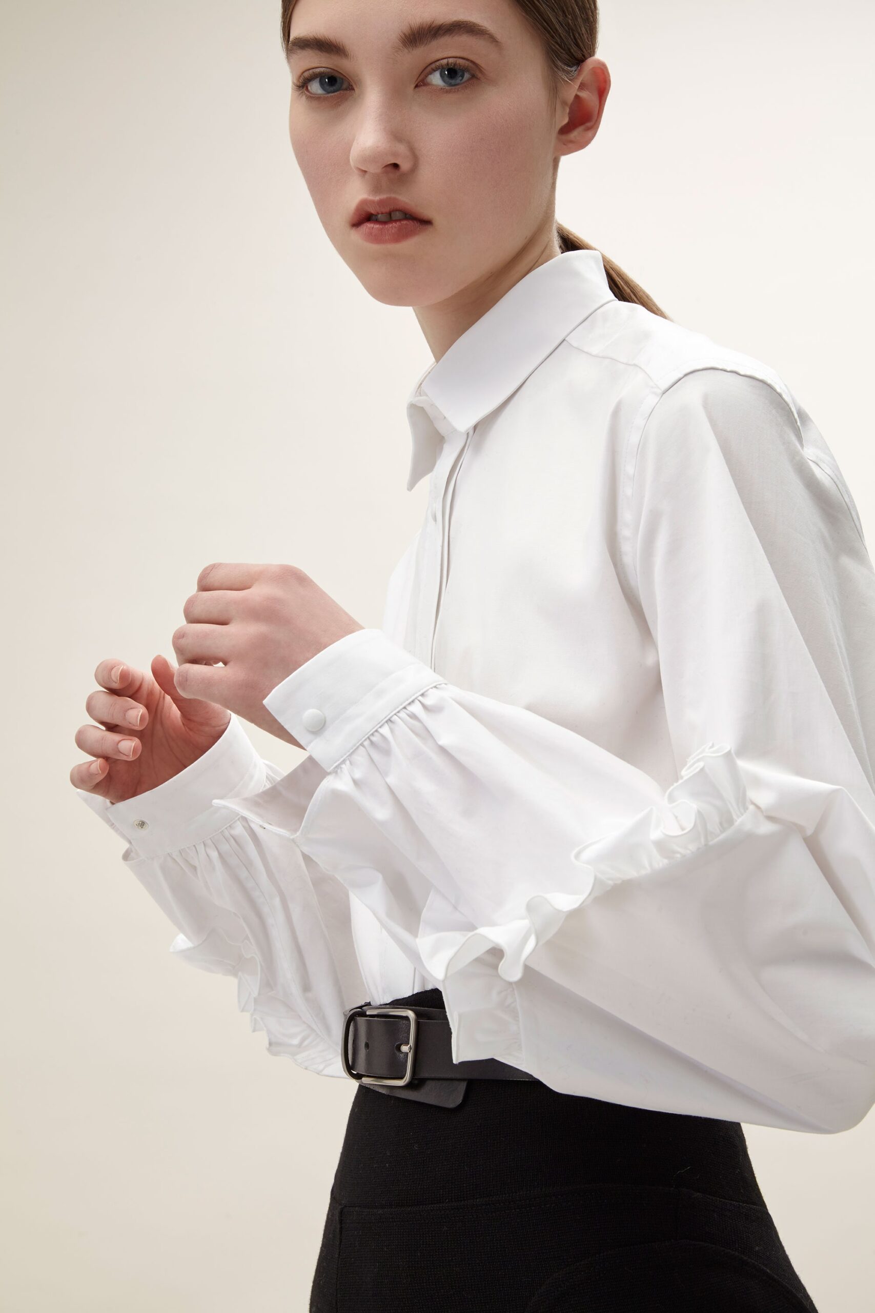 white ruffled shirt and black pants