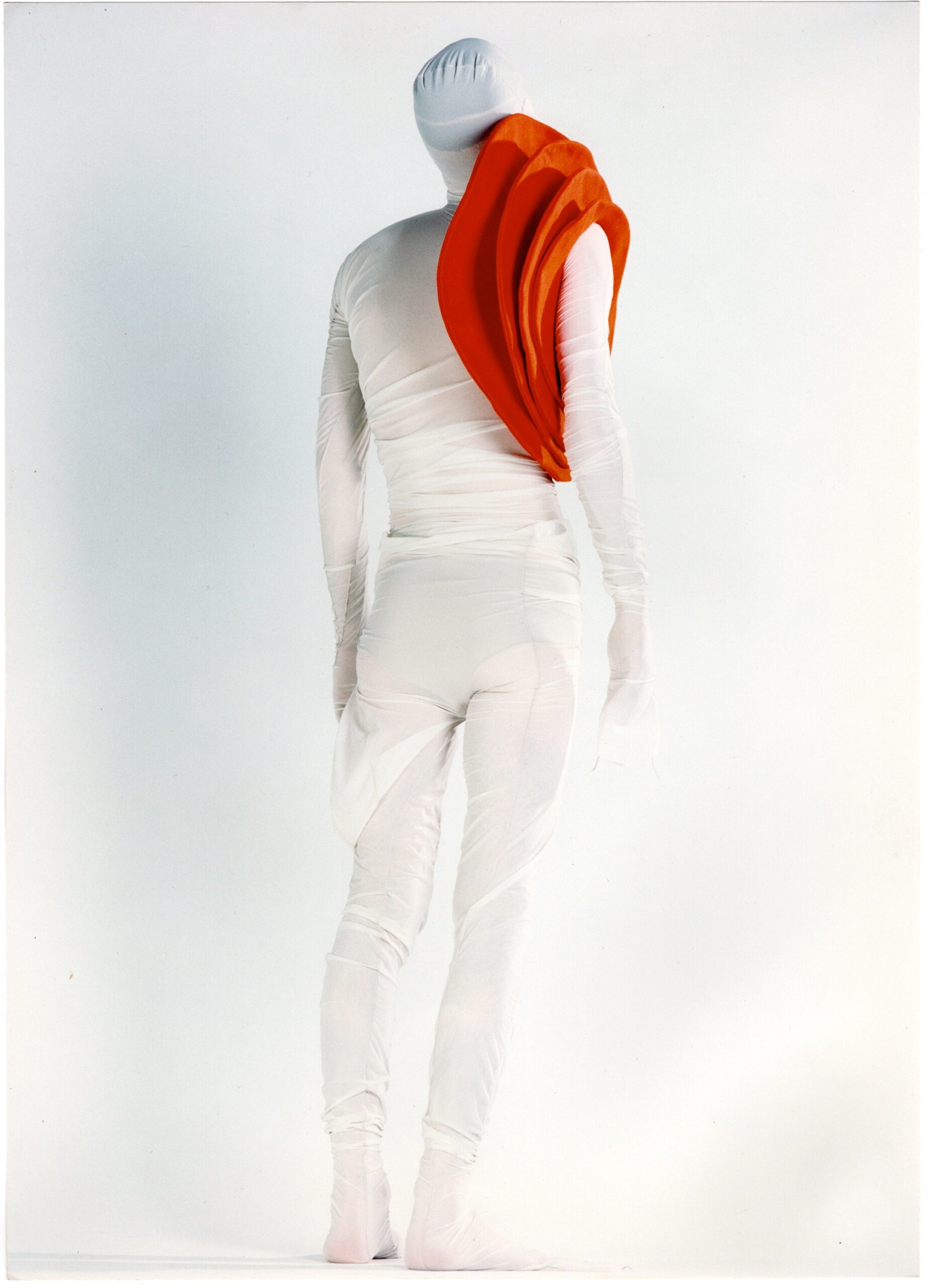 white fitted bodysuit with orange cape