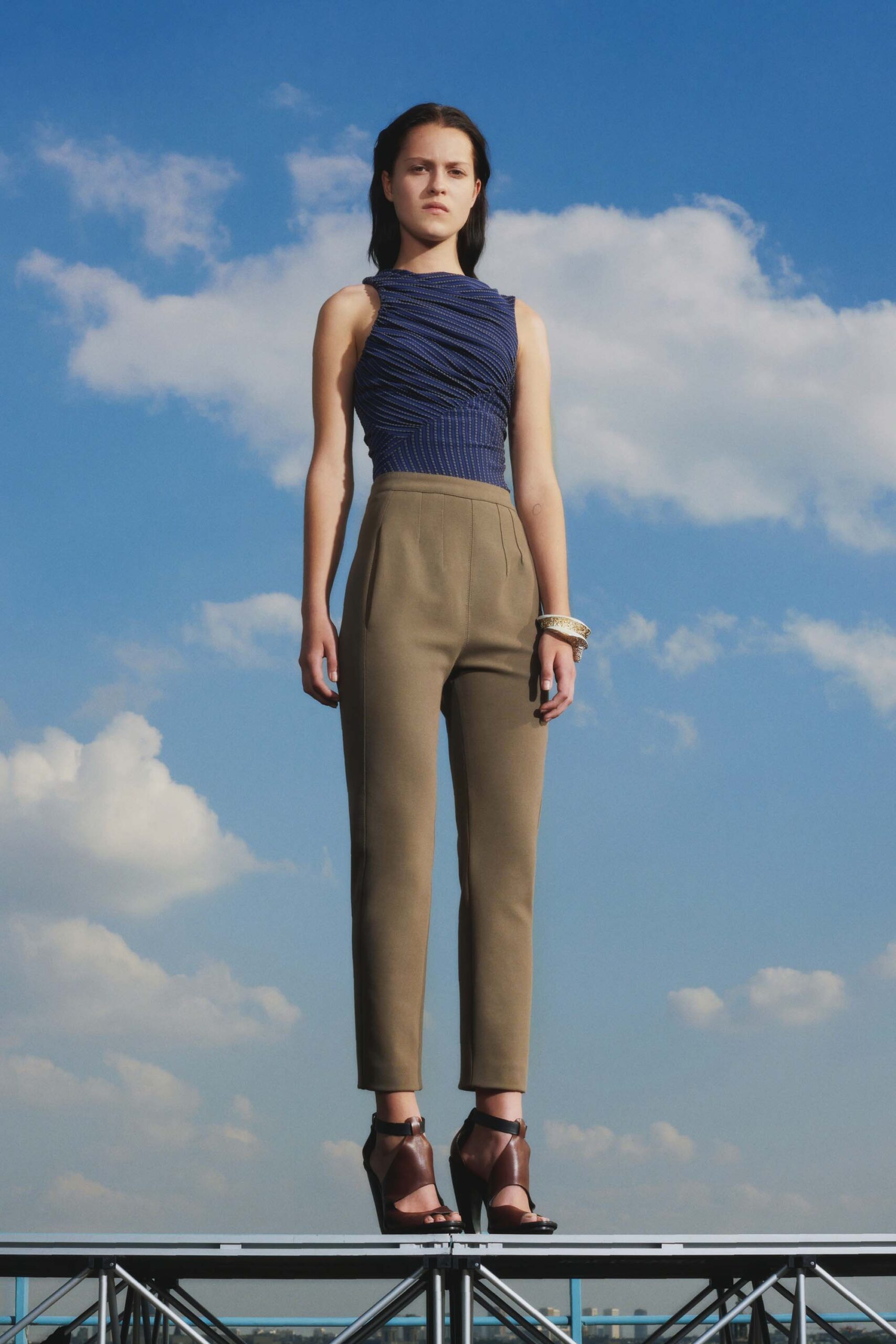 blue fitted top with beige tailored pants
