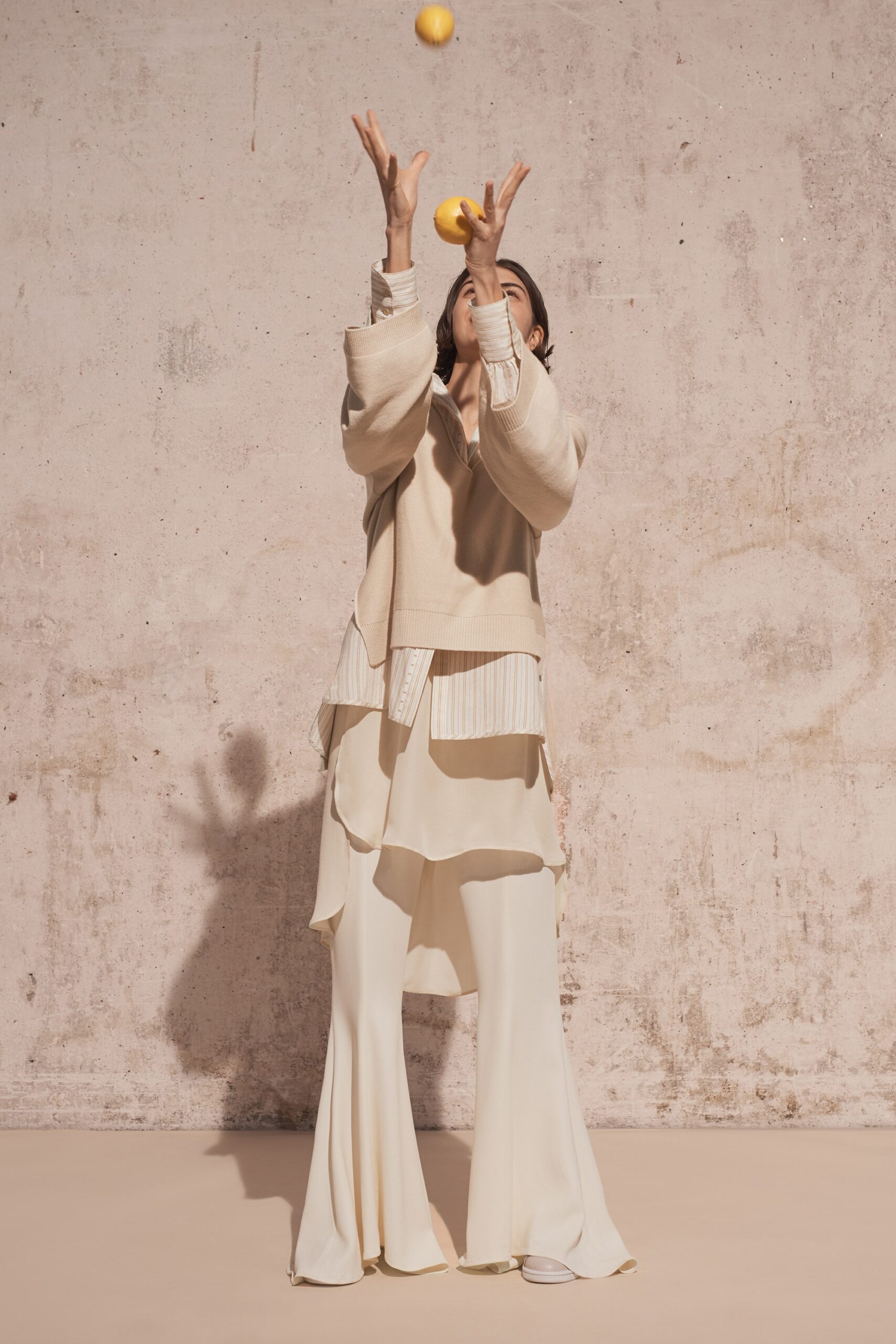 beige relaxed top and white flared pants