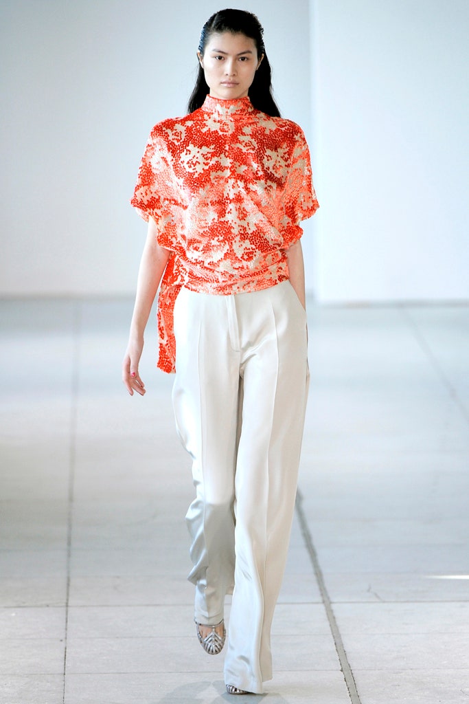 orange printed silk top with white pants