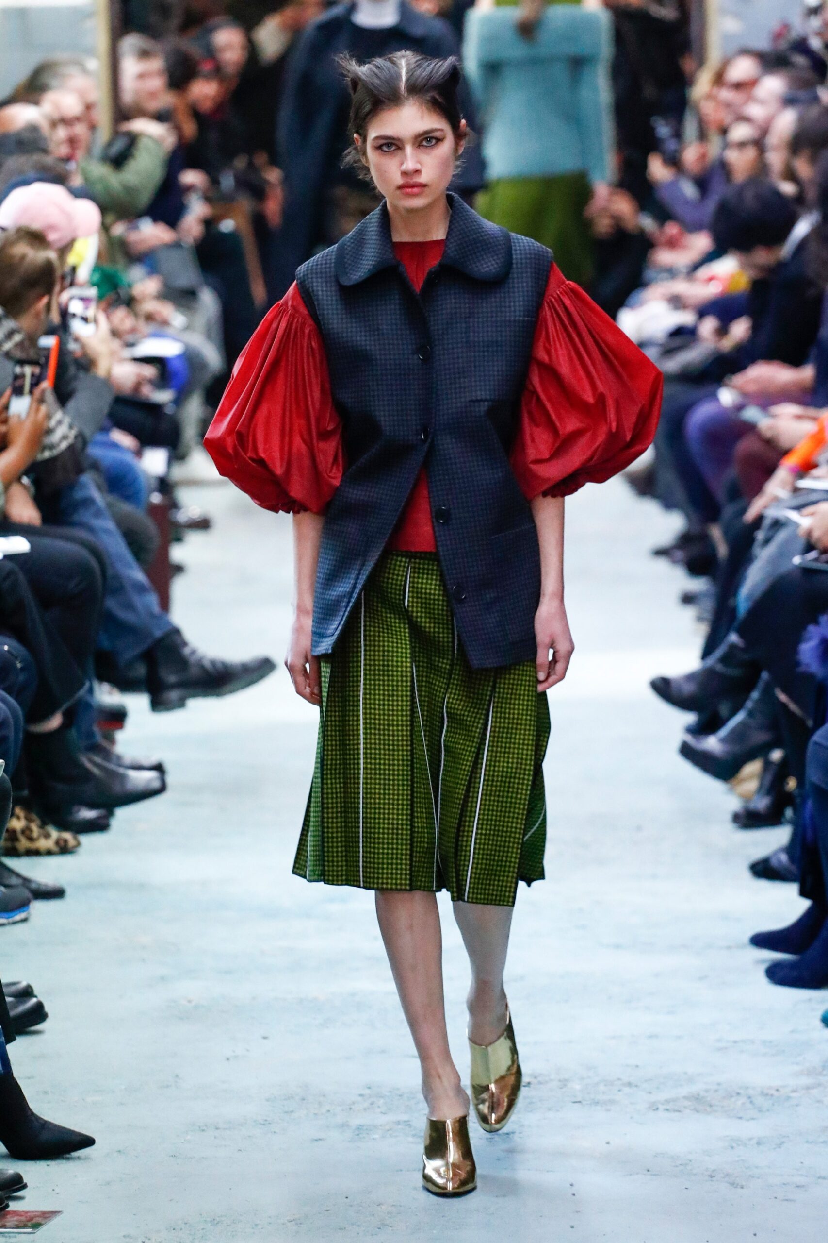 black vest red blouse green pleated skirt