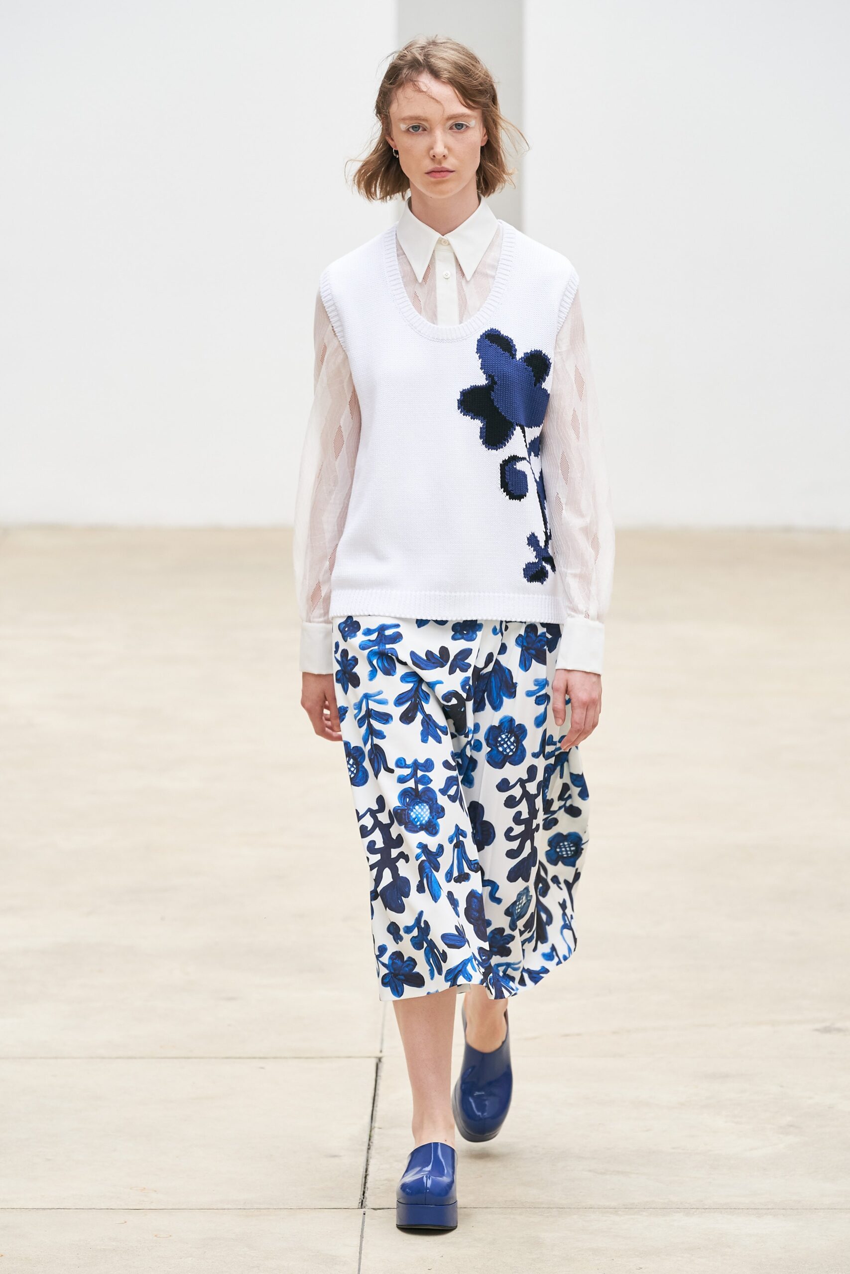 white cotton top with blue vest and skirt