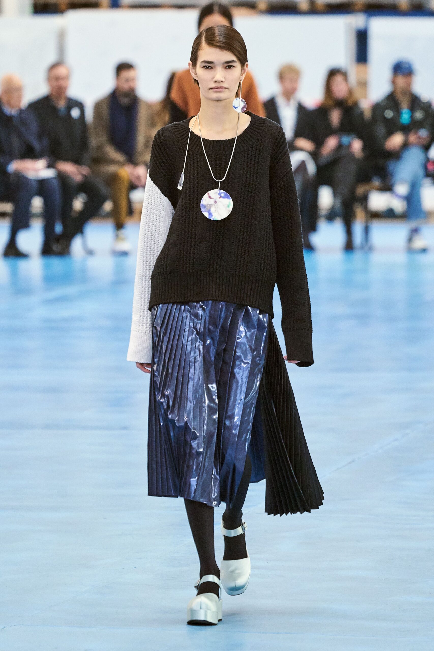 black and white relaxed sweater with pleated blue skirt