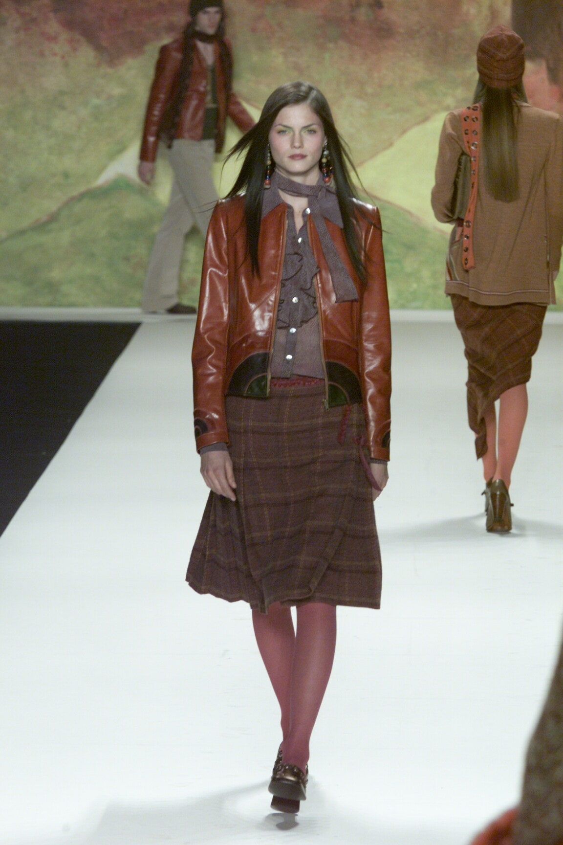 brown leather jacket with gray blouse and pleated skirt