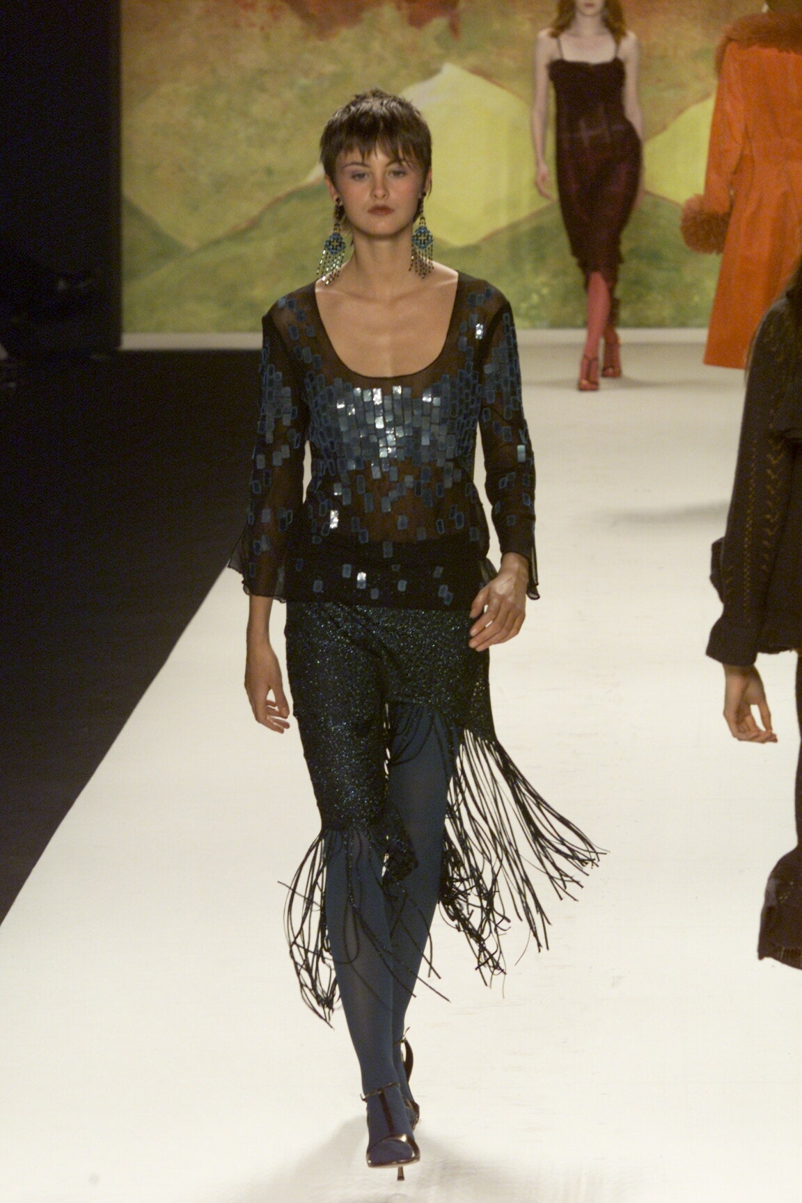 black sequined sleeveless top and blue fringed pants