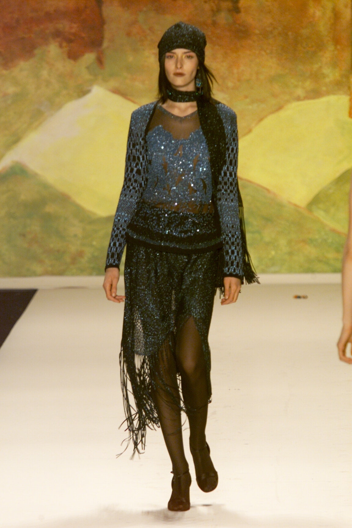 blue sequined fitted top and black fringed skirt