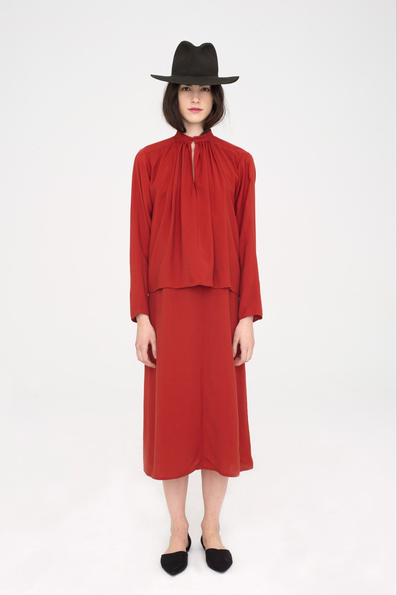 red silk relaxed dress with black hat