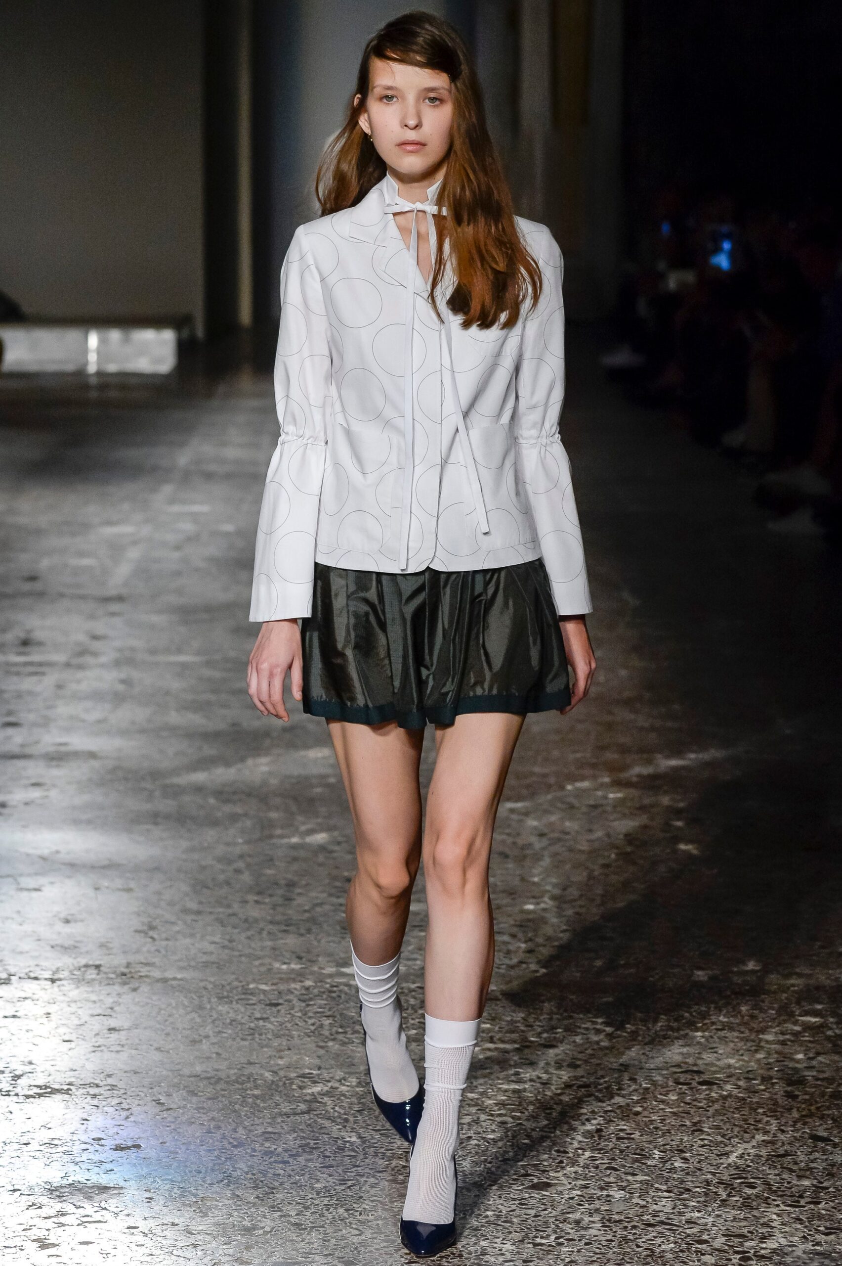 white fitted jacket and black pleated skirt