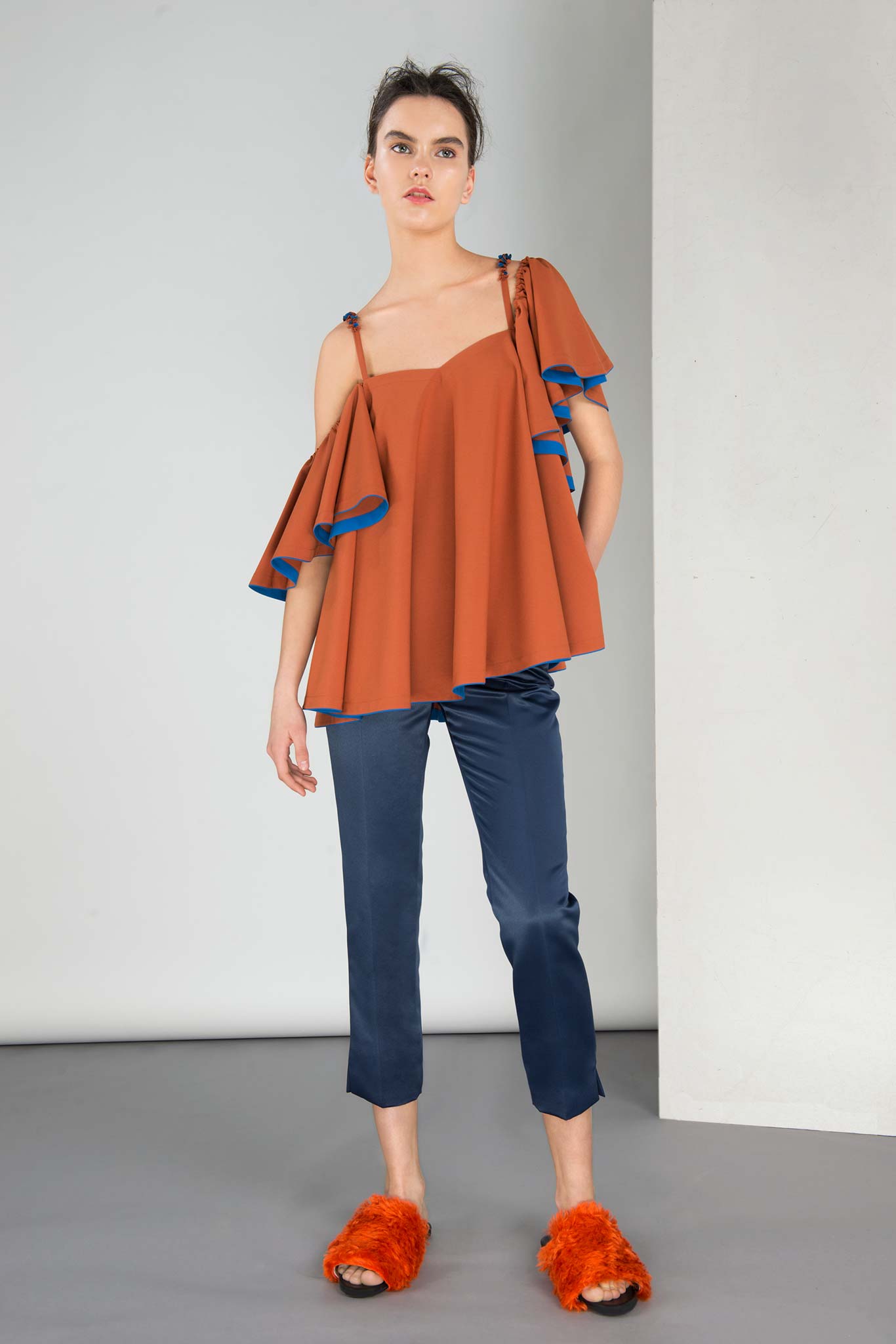 orange ruffled top with blue pants