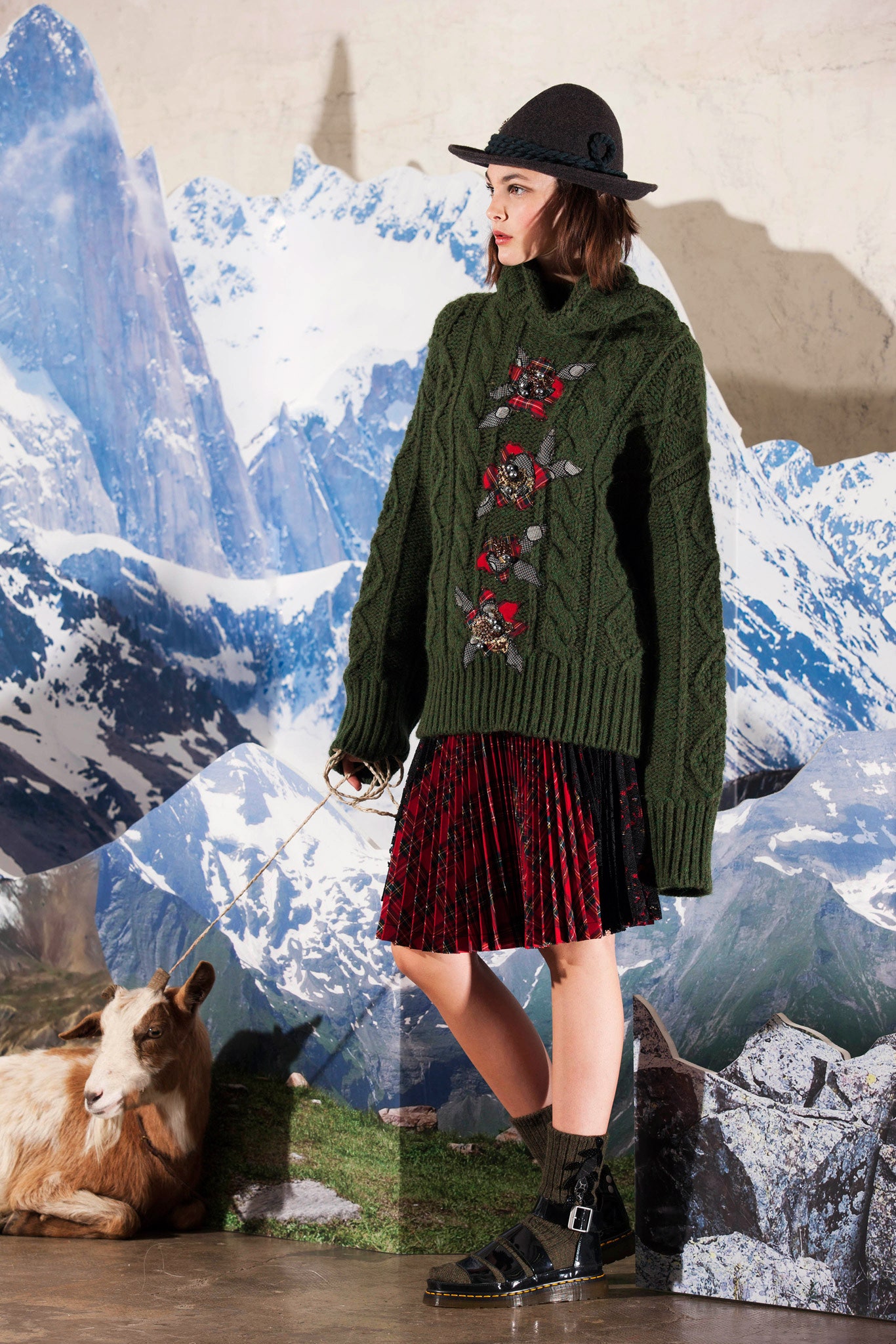 oversized green sweater with pleated red skirt