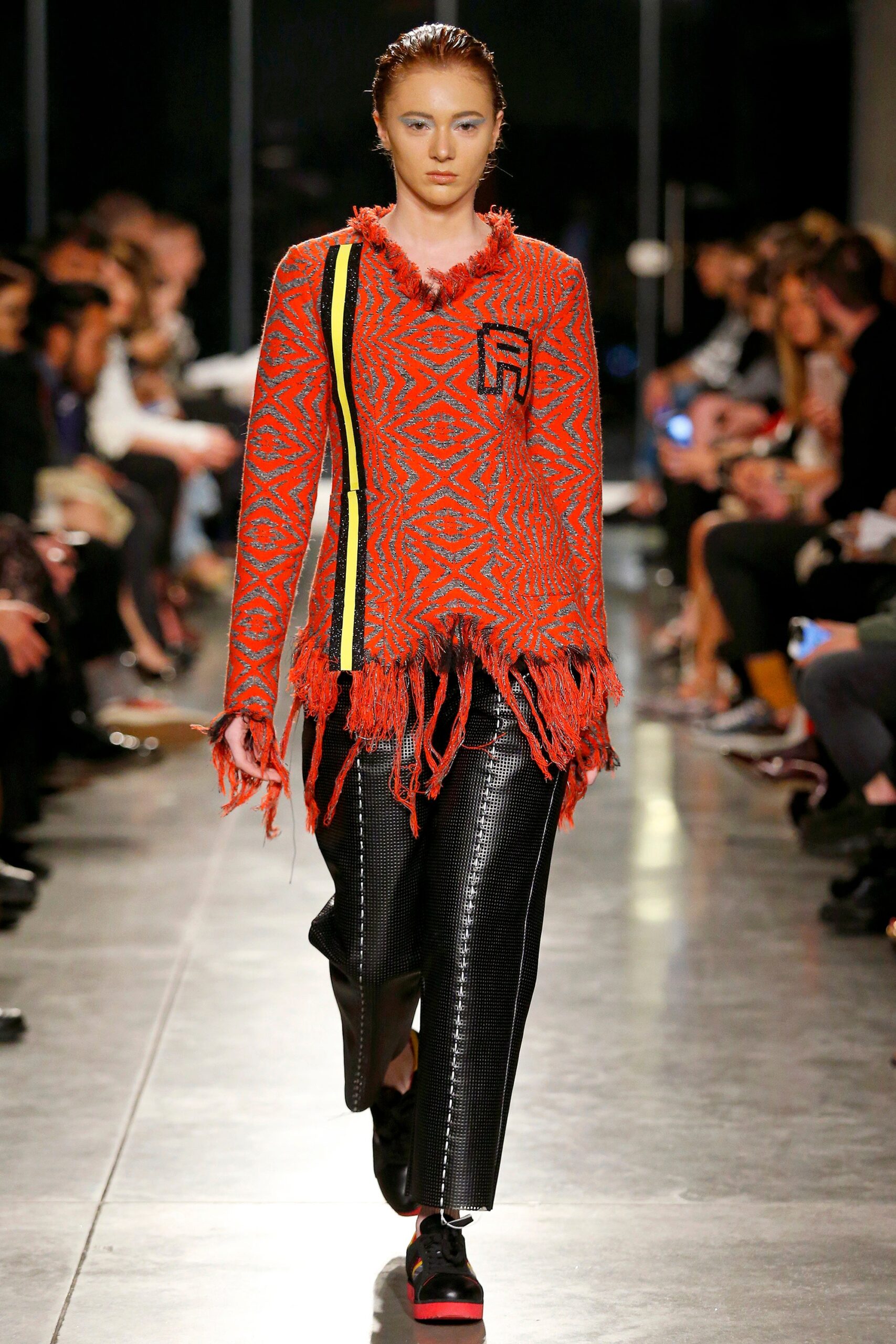 red embroidered relaxed top with black leather pants
