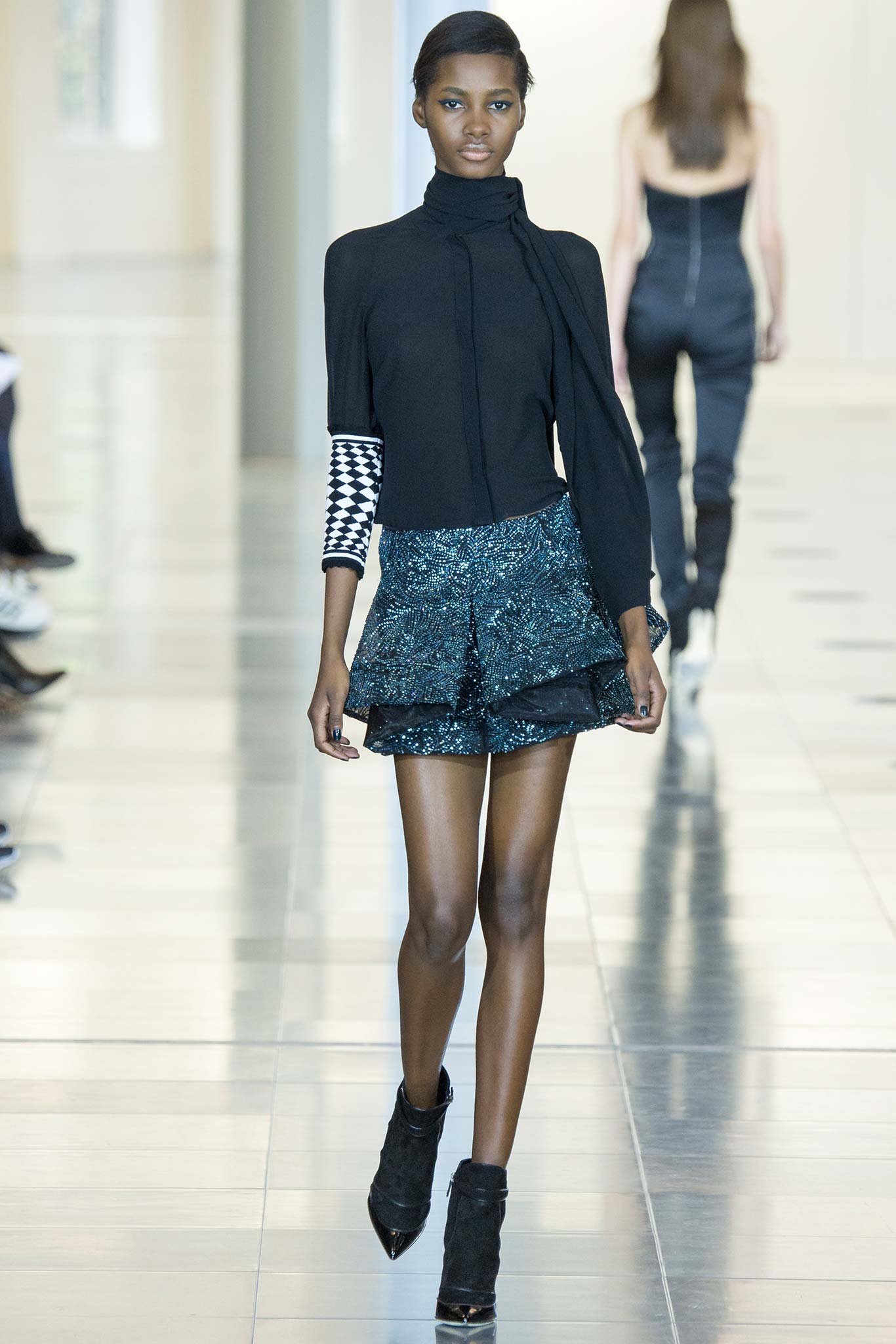 black fitted top with asymmetric design and blue mini skirt