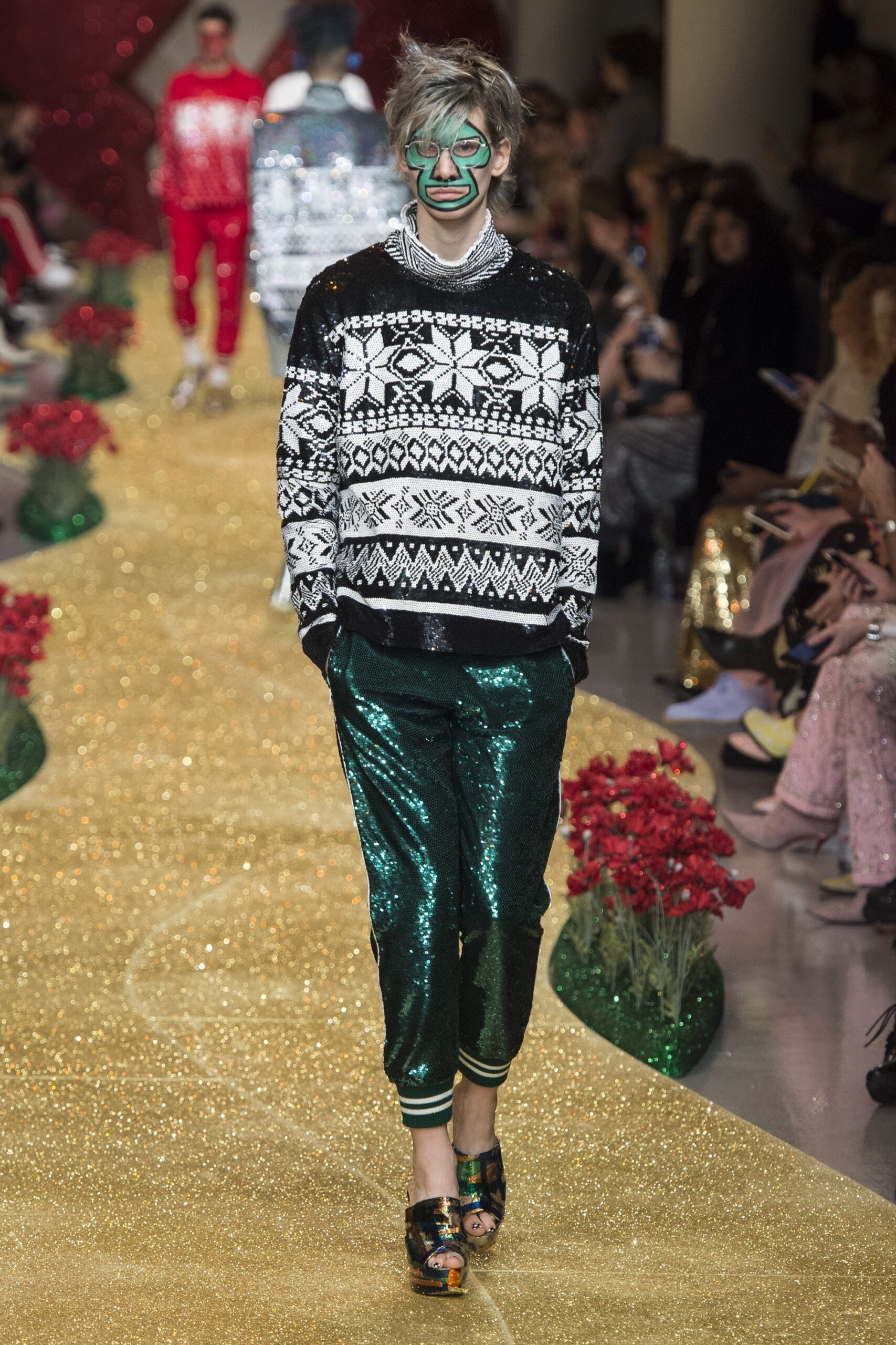 black and white printed sweater with green sequin pants