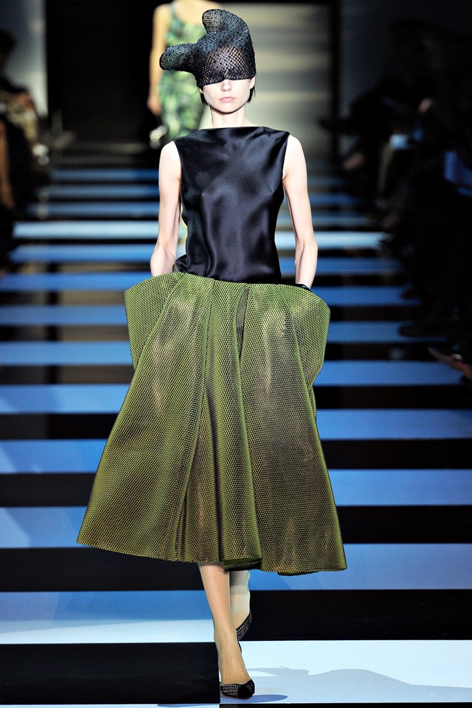 black silk sleeveless top and green pleated skirt