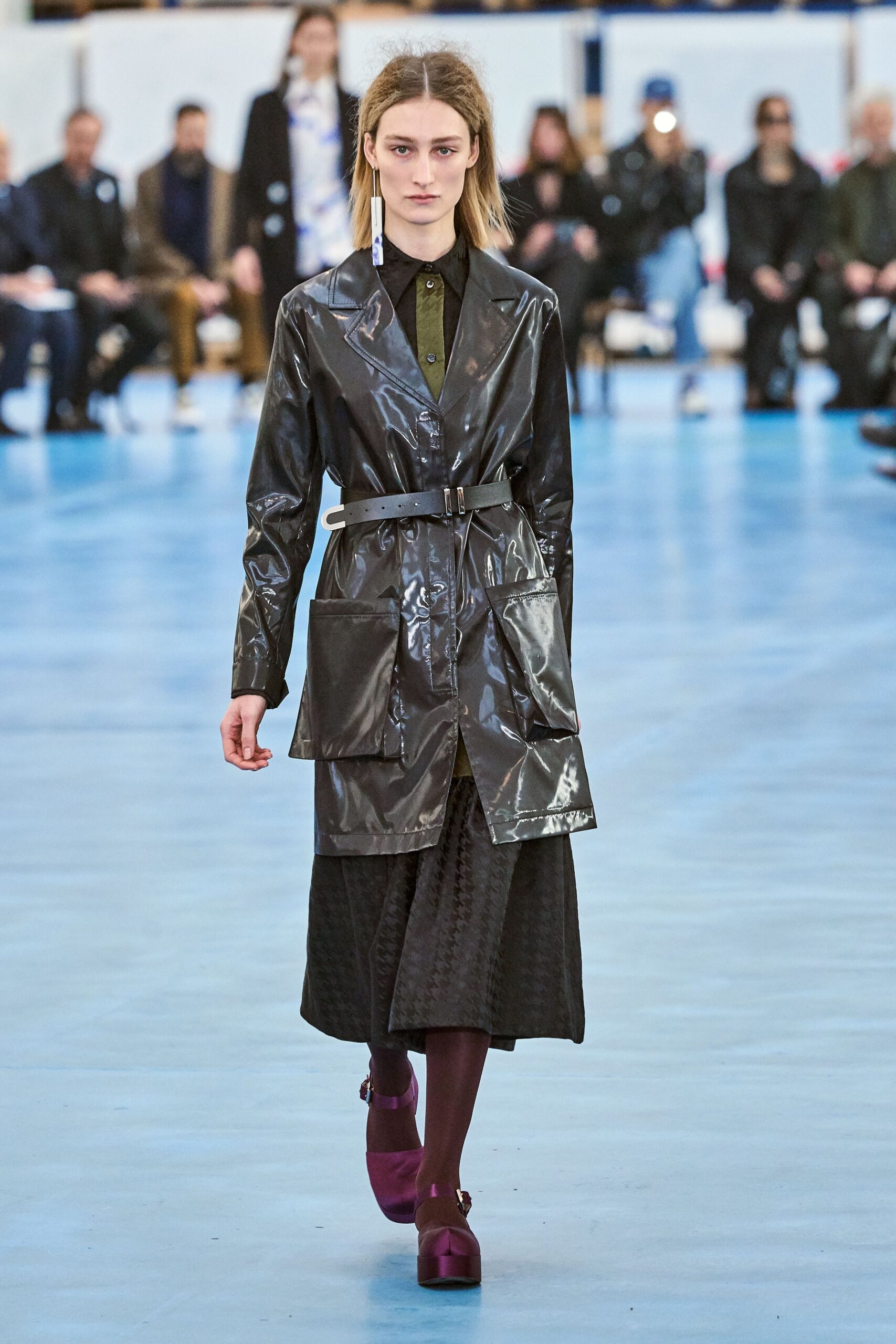 black vinyl coat and pleated dress