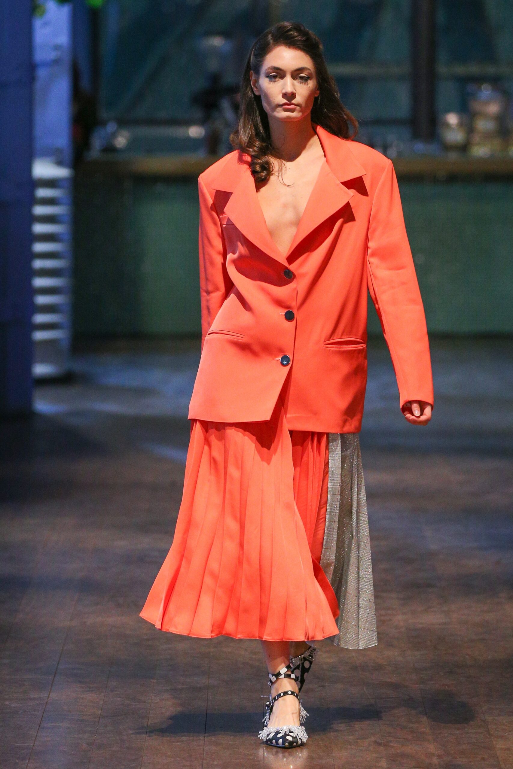 orange blazer and pleated skirt