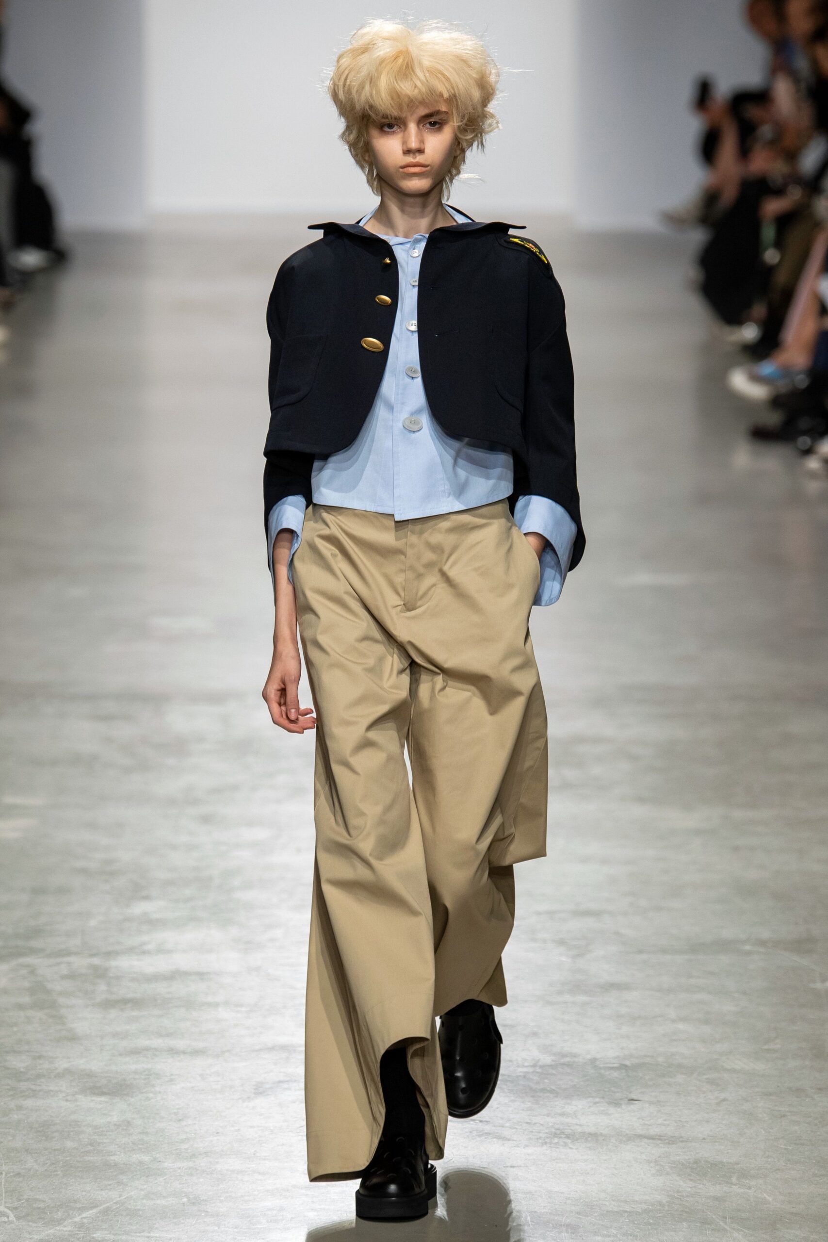 black jacket blue shirt beige pants