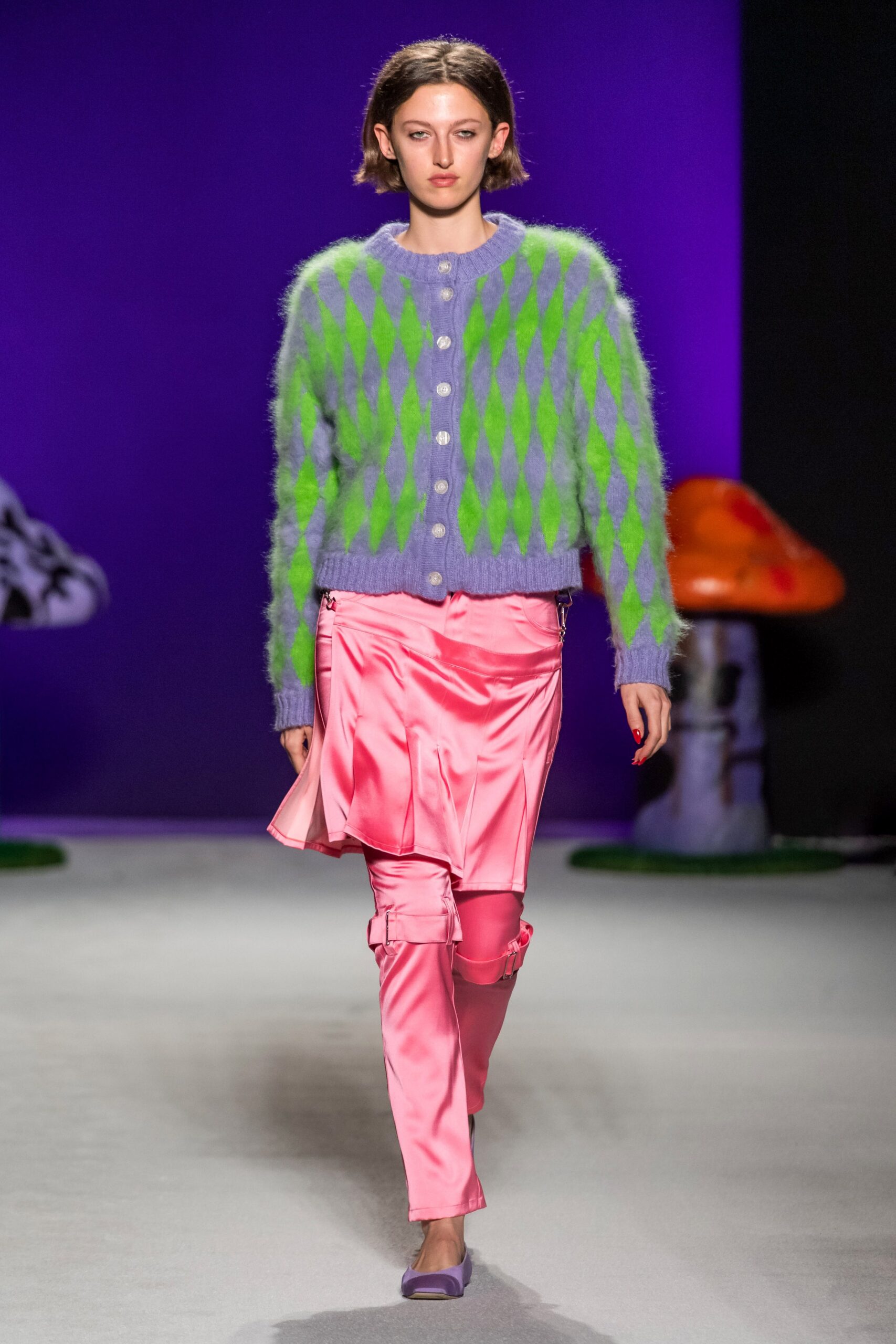 green purple diamond-patterned cardigan with pink skirt