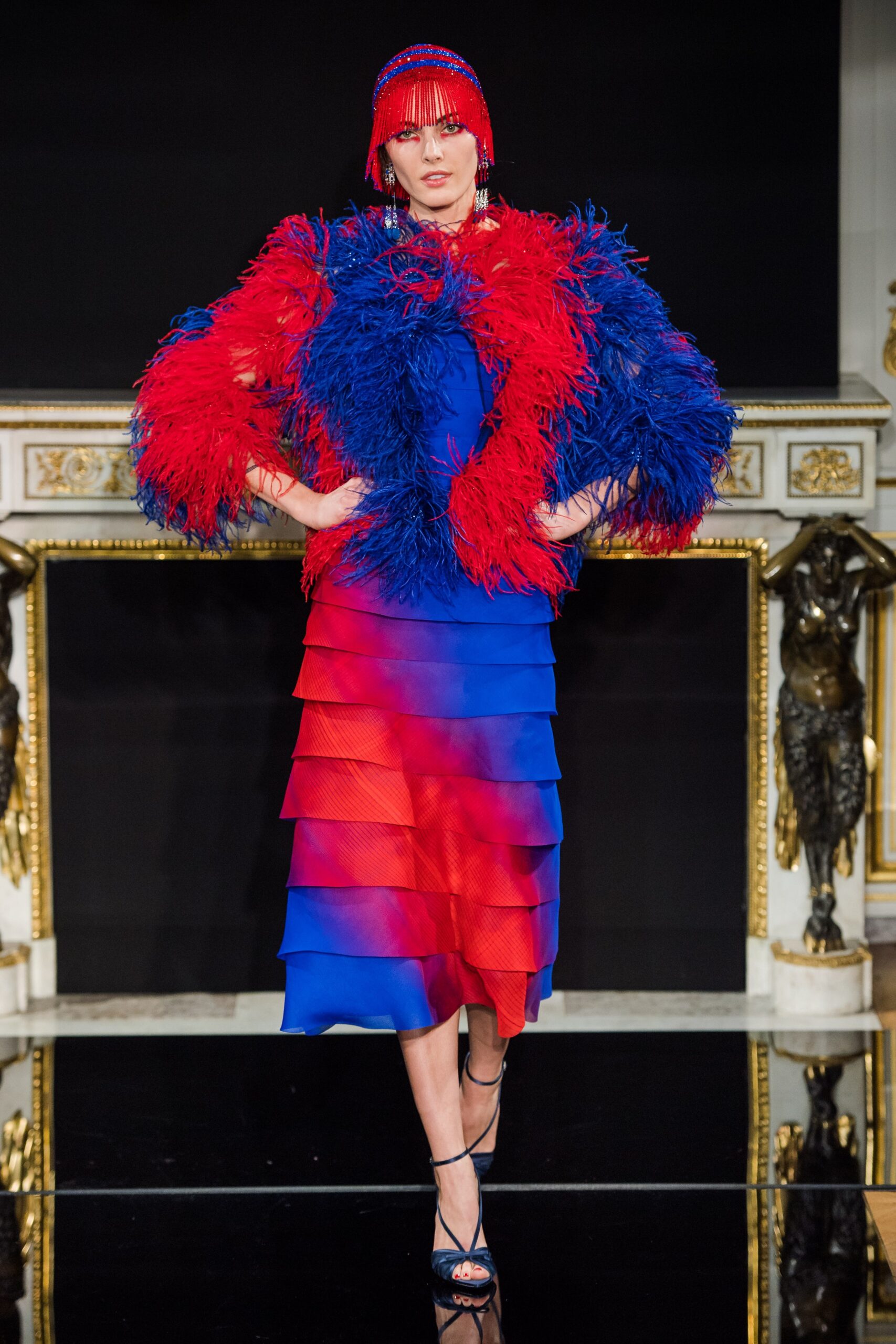 red and blue tiered dress with feather cape