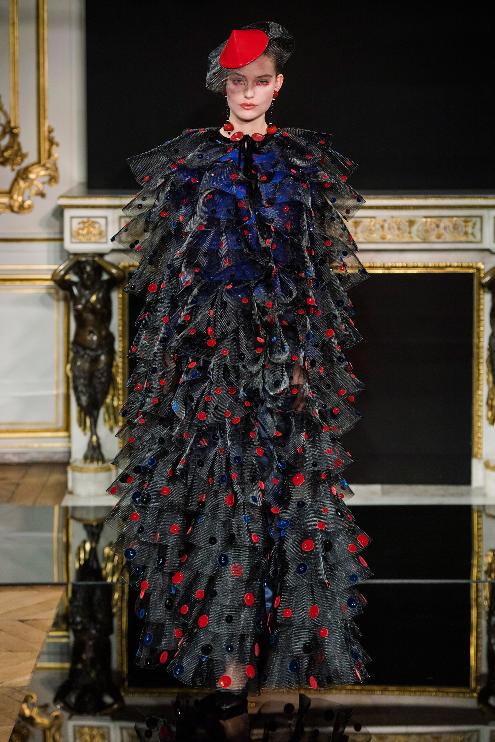 black tulle ruffled gown with red hat
